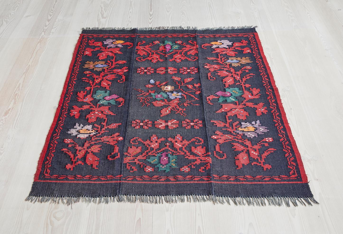 Tappeto tradizionale greco a tessitura piatta con frange. Bellissimo motivo floreale nei colori del marrone, del viola, dell'arancione e del verde.