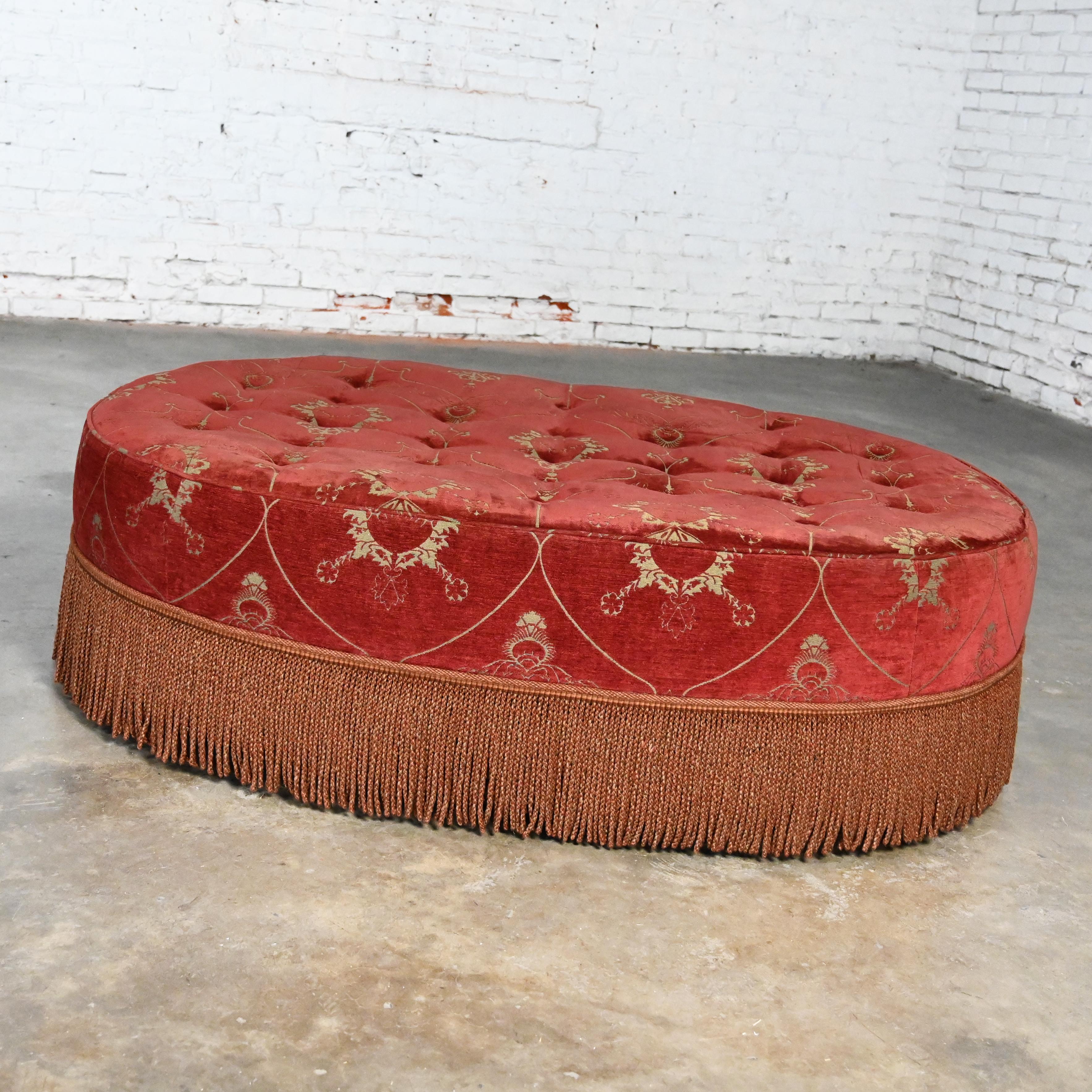 Magnificent vintage Traditional to Transitional large oval cocktail ottoman with rust colored chenille fabric with a button tufted top & bullion fringe trimmed base & square wood legs with angled corners. Beautiful condition, keeping in mind that