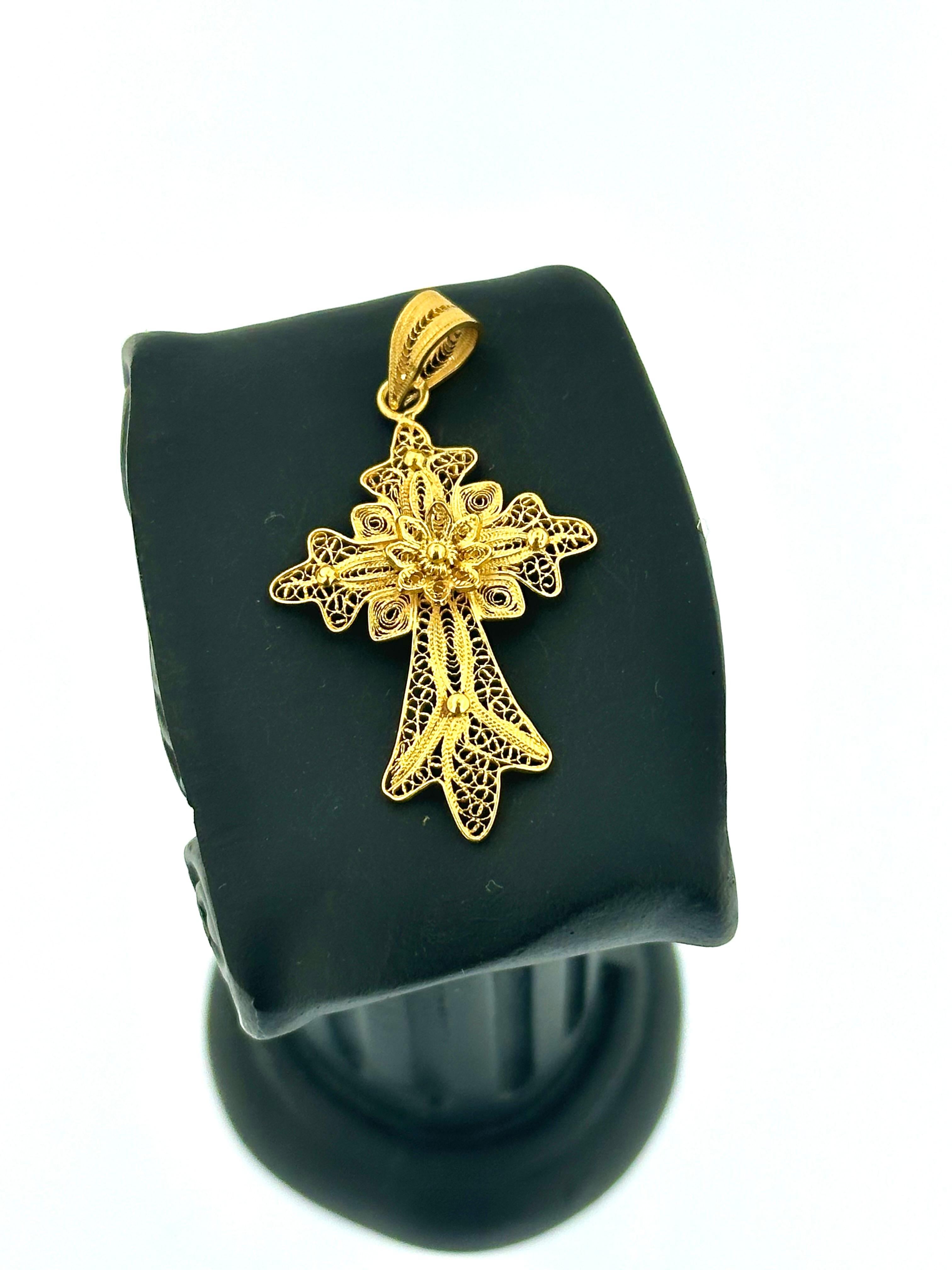 Dieses traditionelle portugiesische Vintage-Kreuz aus 19-karätigem Gelbgold ist eine beeindruckende Darstellung des kulturellen Erbes und der handwerklichen Kunstfertigkeit. Dieses handgefertigte Stück ist mit filigranen Arbeiten versehen, die ein