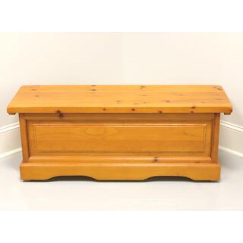 A Traditional style coffer / blanket chest, unbranded. Solid knotty pine with metal hardware. Features chain held lid, ample interior storage, metal side handles, raised front and side panels. Likely made in the USA, in the late 20th