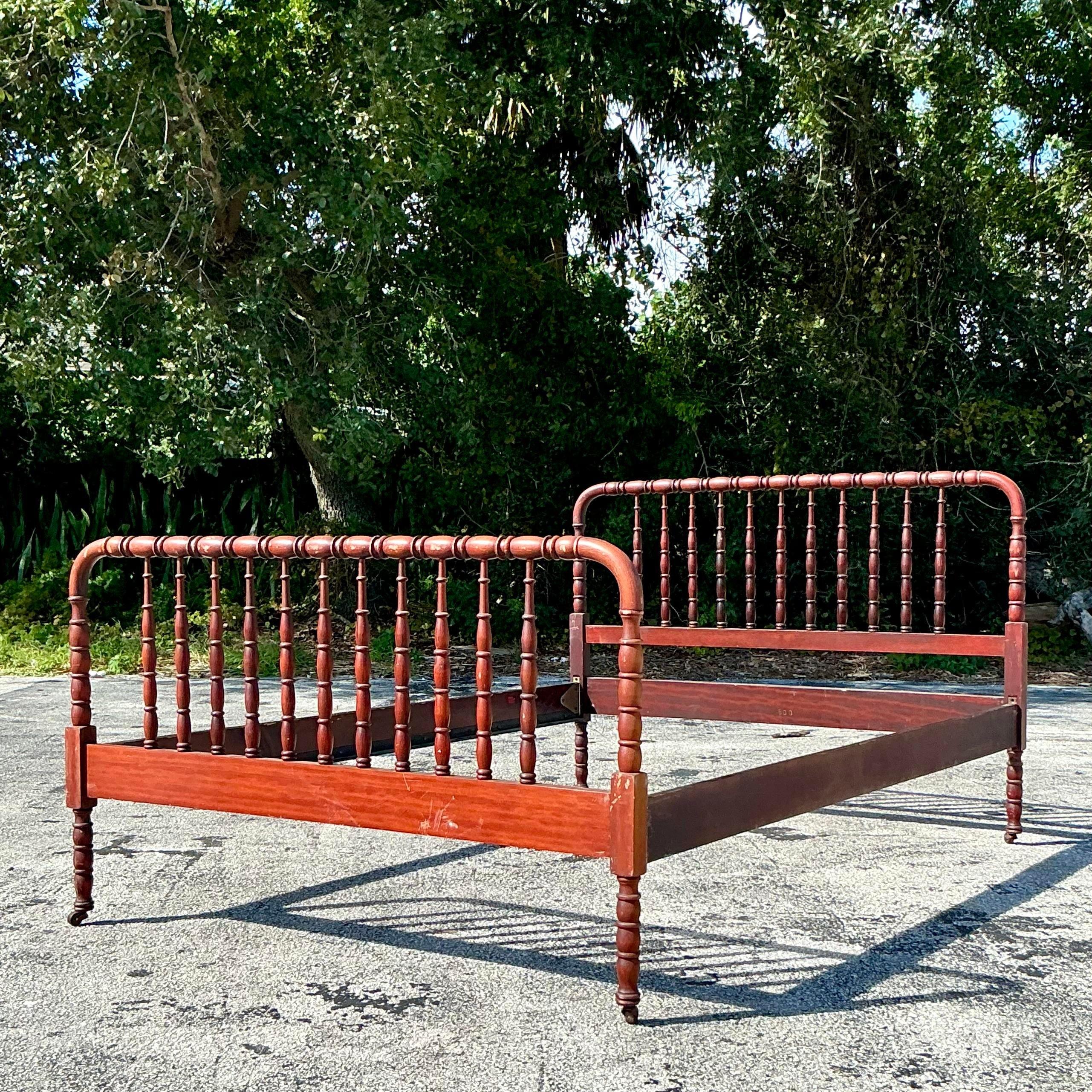 This vintage full bed, inspired by Jenny Lind's iconic style, showcases classic turned wood spindles and a rich, timeless finish. Its elegant curves and sturdy build make it a standout piece, blending antique charm with durable craftsmanship.