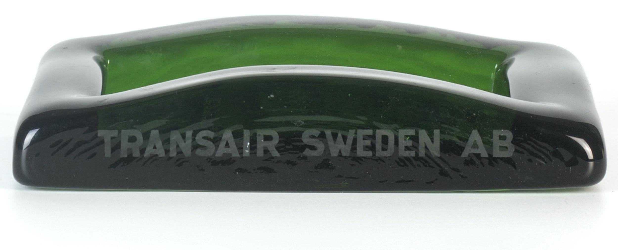 Transair Sweden AB ashtray is a wonderful glass decorative object, realized during the 1970s. 

Very fashionable green colored ashtray. This ashtray was produced by Transair Sweden AB (as reported on the side).

Transair Sweden AB was a charter