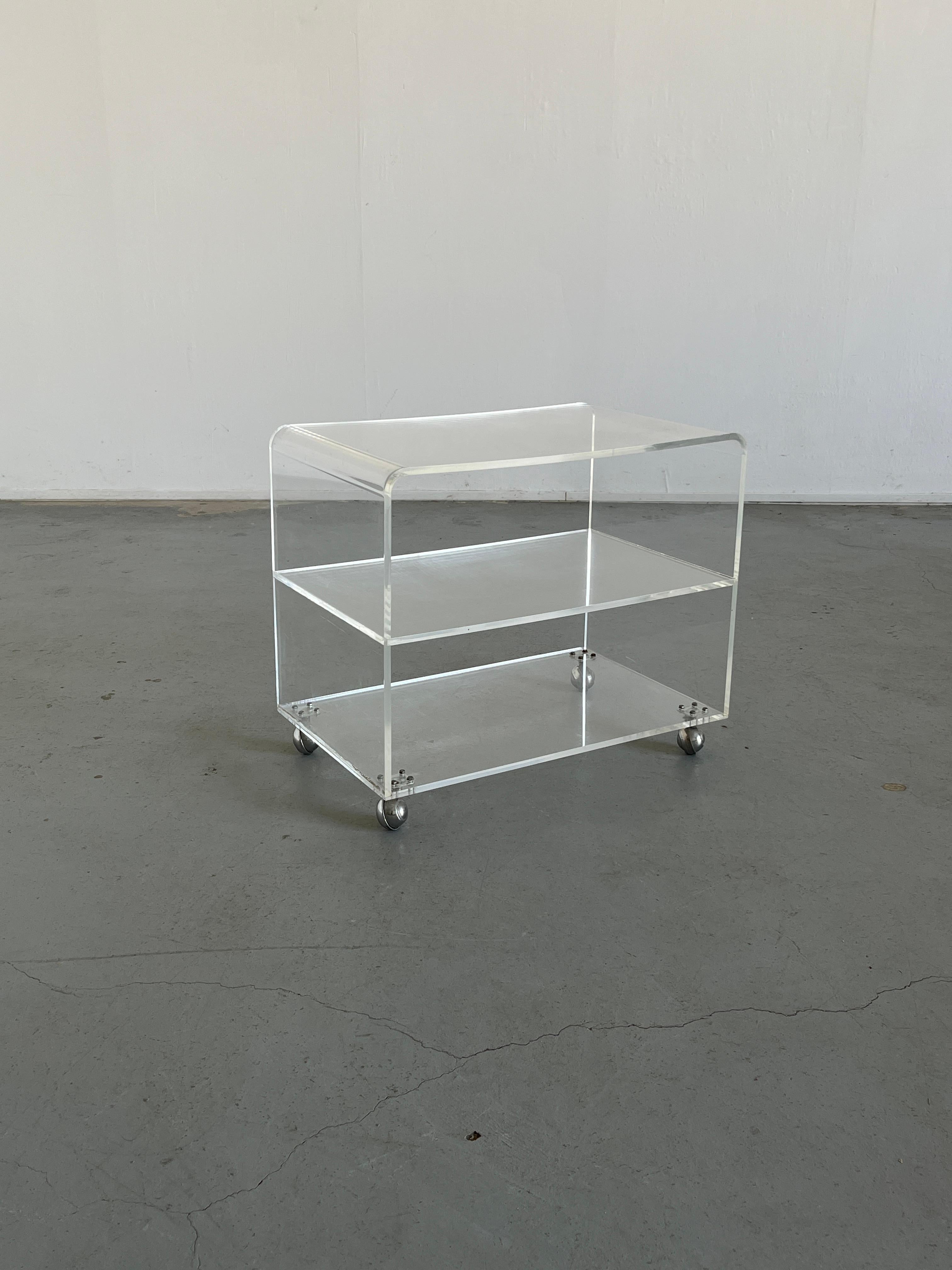 A stylish vintage Italian plexiglas rolling cart, etagere or sideboard.

Overall in good vintage condition with expected signs of age and use, as indicated in the photos. Some scratches are present since it is transparent plexiglass but nothing too