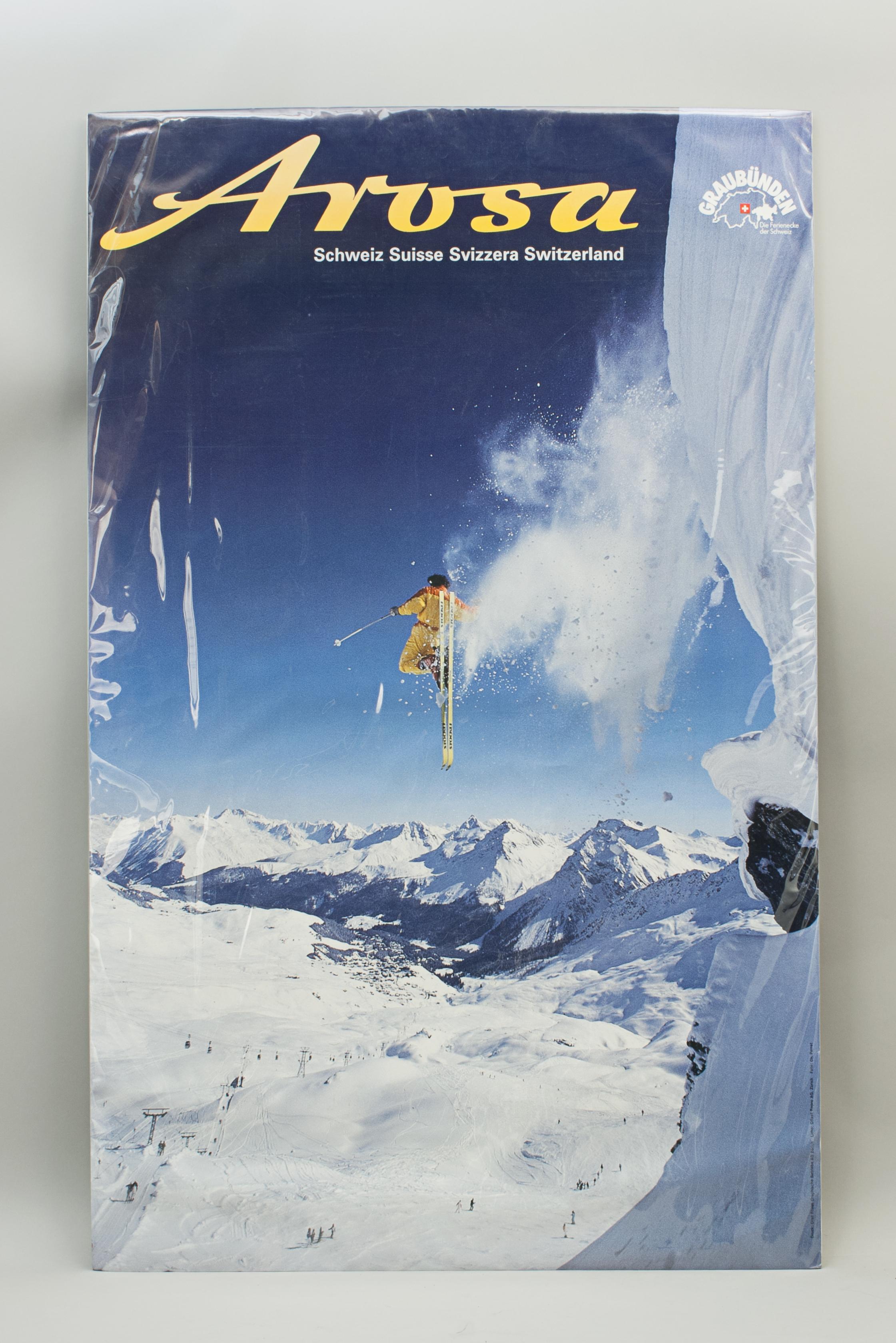 Vintage ski resort poster
A fine ski resort poster entitled in yellow writing across the top 'Arosa'. The photographic poster (color-offset print) is a scenic view of the ski slopes and lifts with a skier in mid air, having just made a jump. Arosa