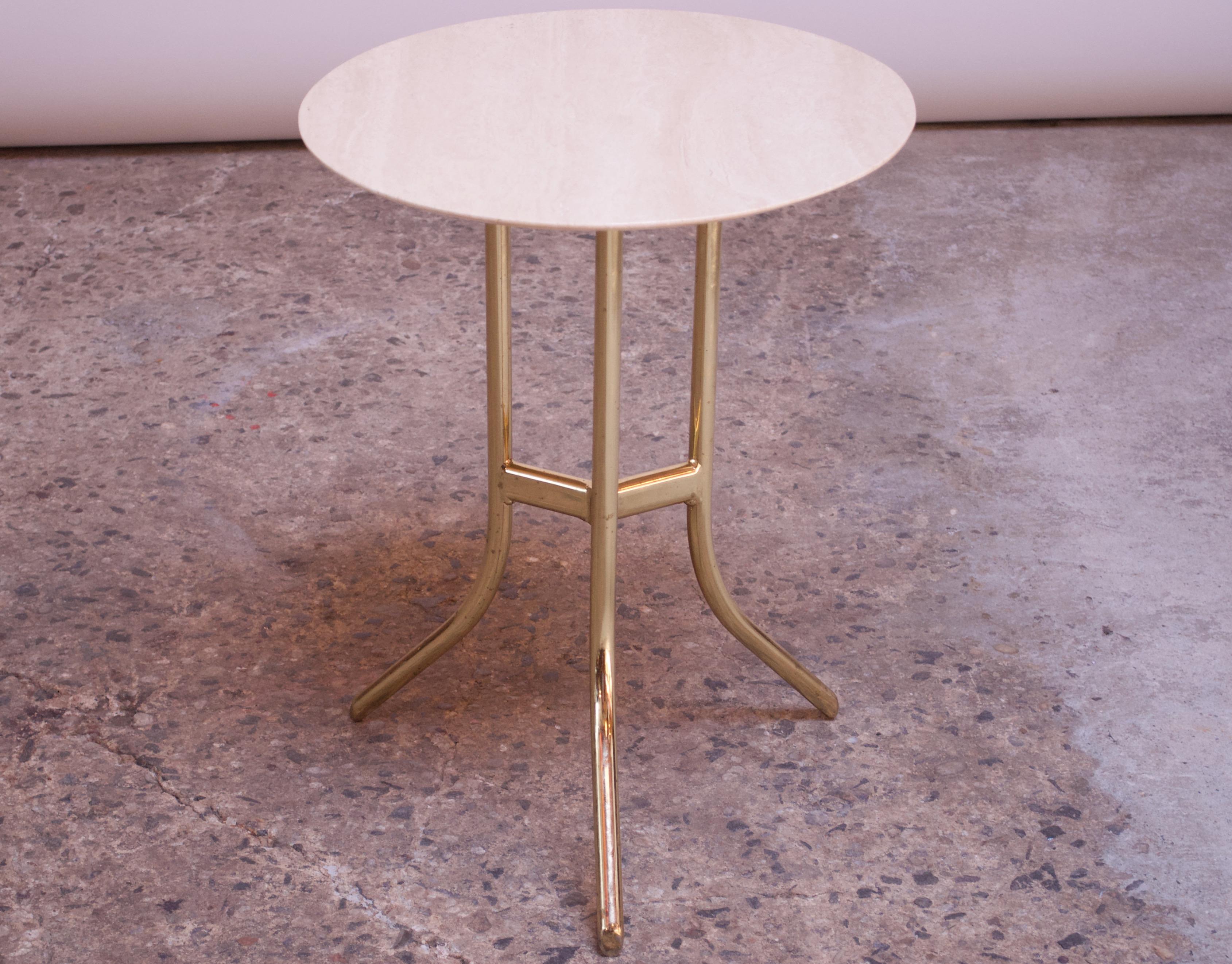Elegant side table (circa 1980s, USA) composed of a round, bevelled travertine top adhered to a polished brass three-legged base. In the style of Cedric Hartman but unsigned.
Top is in excellent, vintage condition, and base shows minor spots of