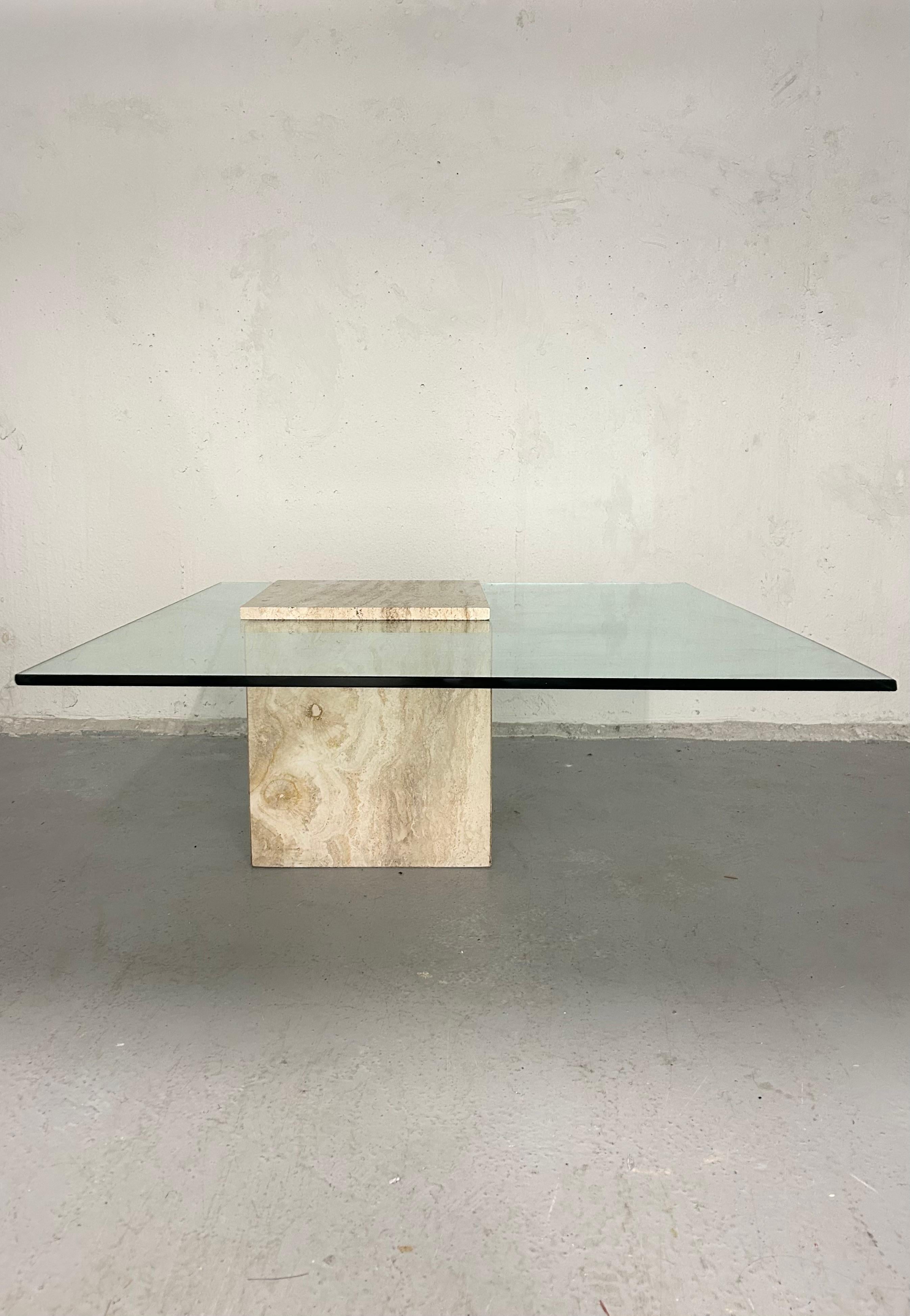 Vintage travertine and glass coffee table. Glass is sandwiched between a top piece of travertine and bottom hollow cube of travertine. Comes together by a bolt attached to the top piece that goes through a hole in the glass and twists into the