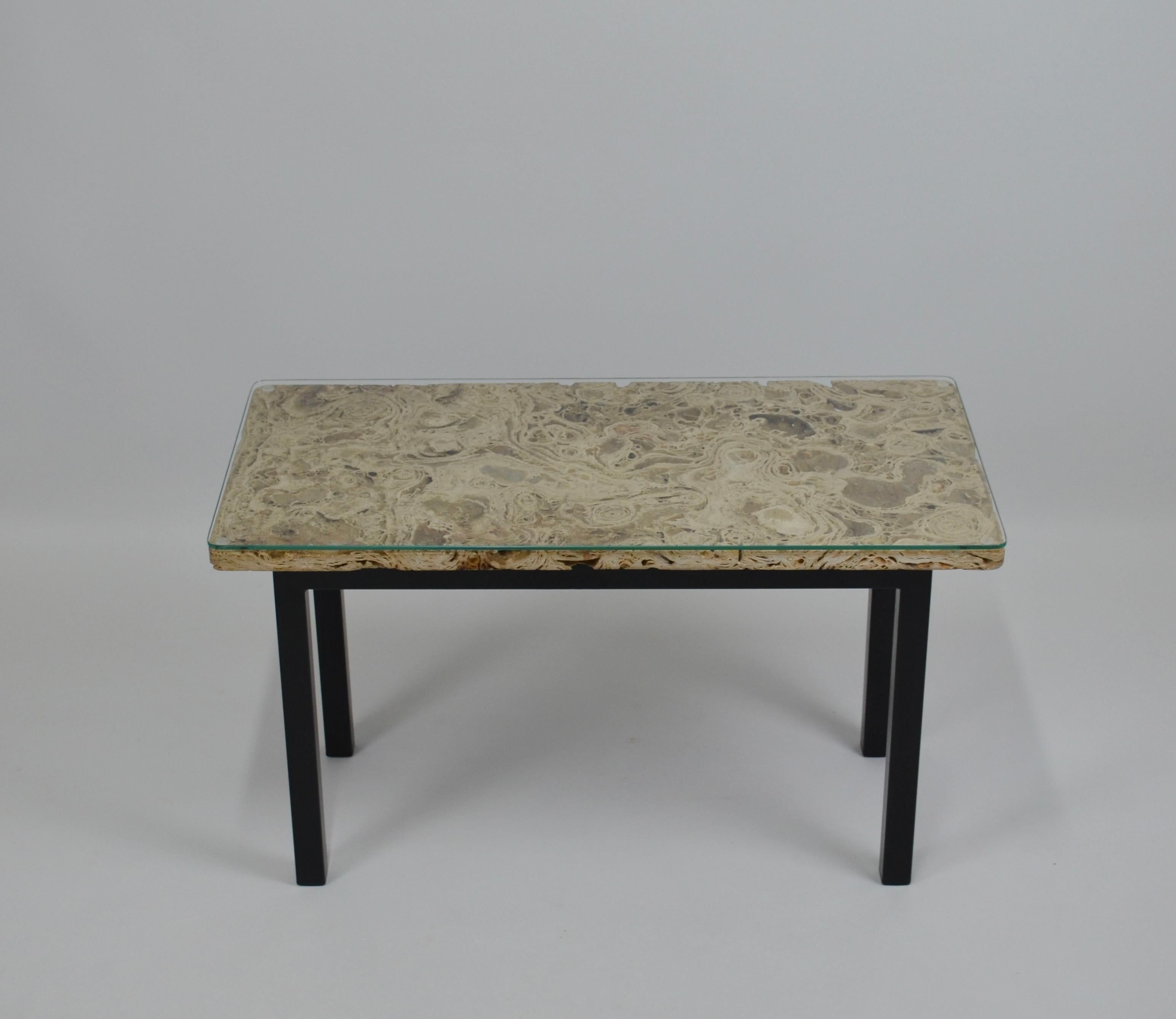 Magnificent coffee table with travertine top mounted on a black painted metal structure.
A glass top, 0.5 cm (0.2 in) thick, cut to measure and beveled, makes it easier to use while protecting this splendid stone. The travertine block is 2 cm (0.8