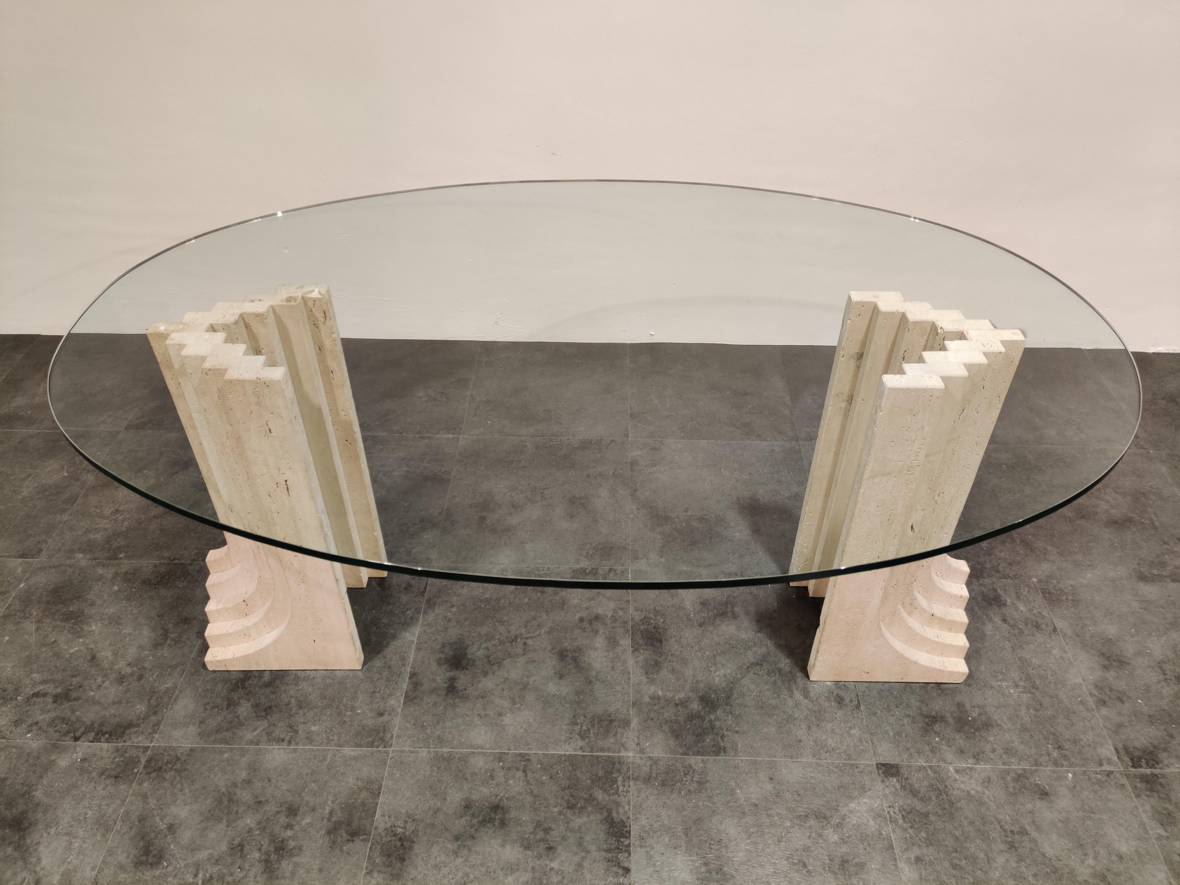Exquisite travertine dining table in the style of Carlo Scarpa's Samo dining table.

Beautiful architectural piece made of solid travertine with a thick oval glass top.

Timeless design.

The two travertine bases can easily be put in the