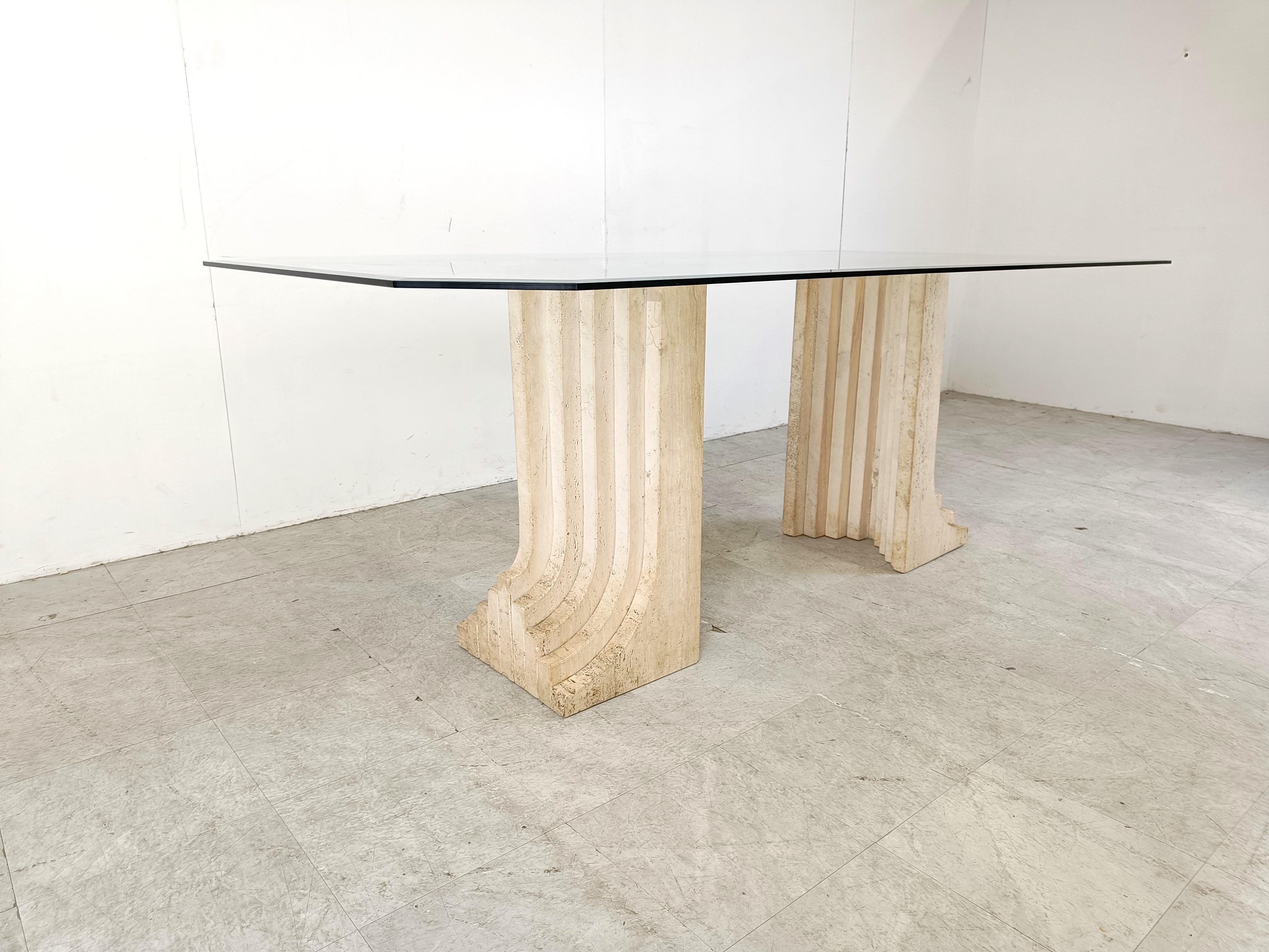 Exquisite travertine dining table in the Style of Carlo Scarpa's Samo dining table.

Beautiful architectural piece made of solid travertine with a thick beveled glass top

Timeless design.

The two travertine bases can easily be put in the center,