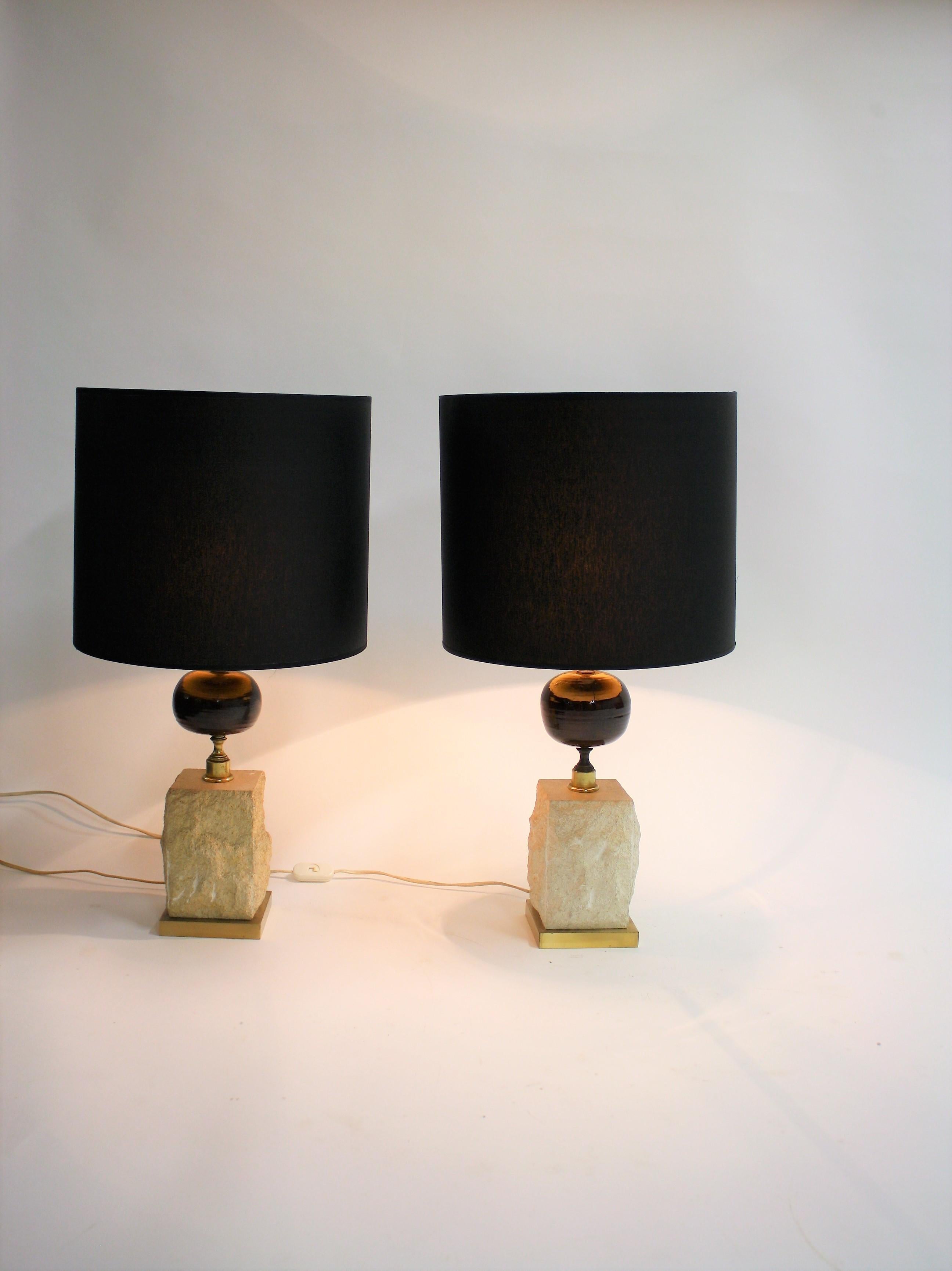 Vintage midcentury brass table lamps with a natural travertine stone base and a wooden centerpiece.

Thess handsome lamps come with custom made gold finish shades.

Maison Barbier style.

Very good condition,slight patinated brass.

Tested