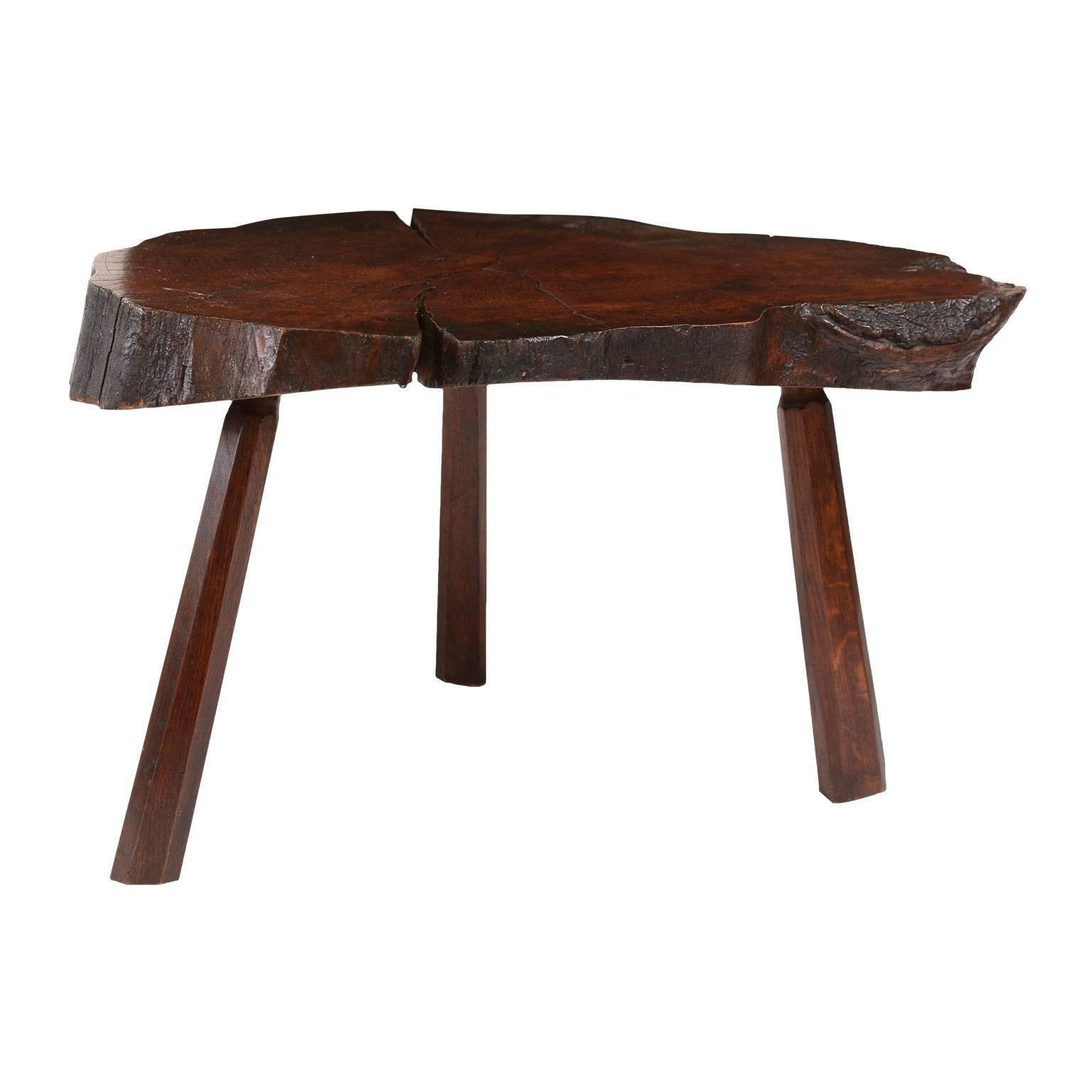 Vintage tree trunk coffee table - or low table - with natural edge from the cross-section of a tree trunk. Purchased in Belgium, this table is supported by three pegged-construction wooden legs and features a rich, warm patina.