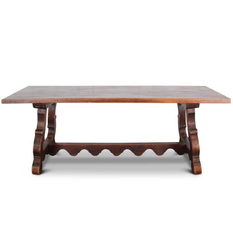 A vintage, solid plank, Spanish style trestle table, with canted legs joined by a scalloped stretcher, circa 1950.





    