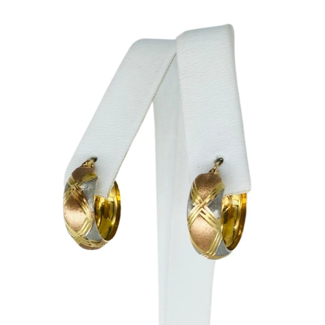 Vintage Tri-Color Gold Hoop Earrings 14k Gold.
Die Ohrringe sind 6,5 mm breit und haben einen Durchmesser von 18 mm. Die Ohrringe sind in Weißgold und Roségold mit einem Diamantenstaubmuster zwischen dem X-Design versehen. Die Ohrringe wiegen 1,7 g