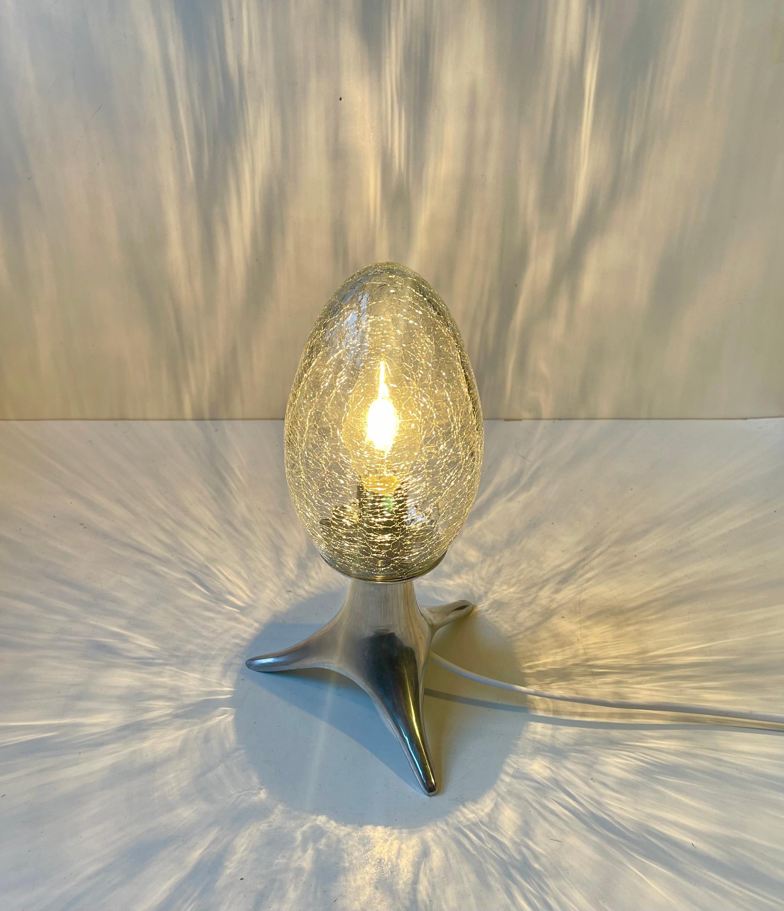 Unusual Scandinavian or Italian Table lamp featuring an egg-shaped craquelé glass shade on a stylish polished aluminum tripod base. Unknown Scandinavian or Italian maker/design circa 1980-90 in a style reminiscent of Concept Obscurs Cadiera by