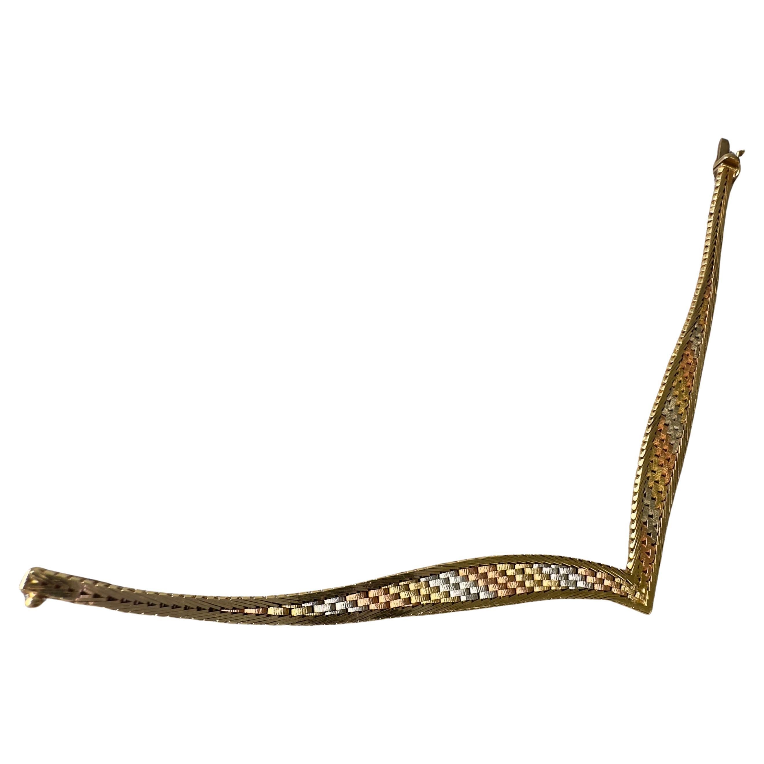 Vintage Tri-Tone 14K Italian Gold Bracelet

This complex woven chain bracelet is comprised of interlocking 14K tri-tone yellow, white, and rose gold components framed in yellow gold. Fluctuating in width from 8.5 - 3.7 mm, it lays flat on a wrist up