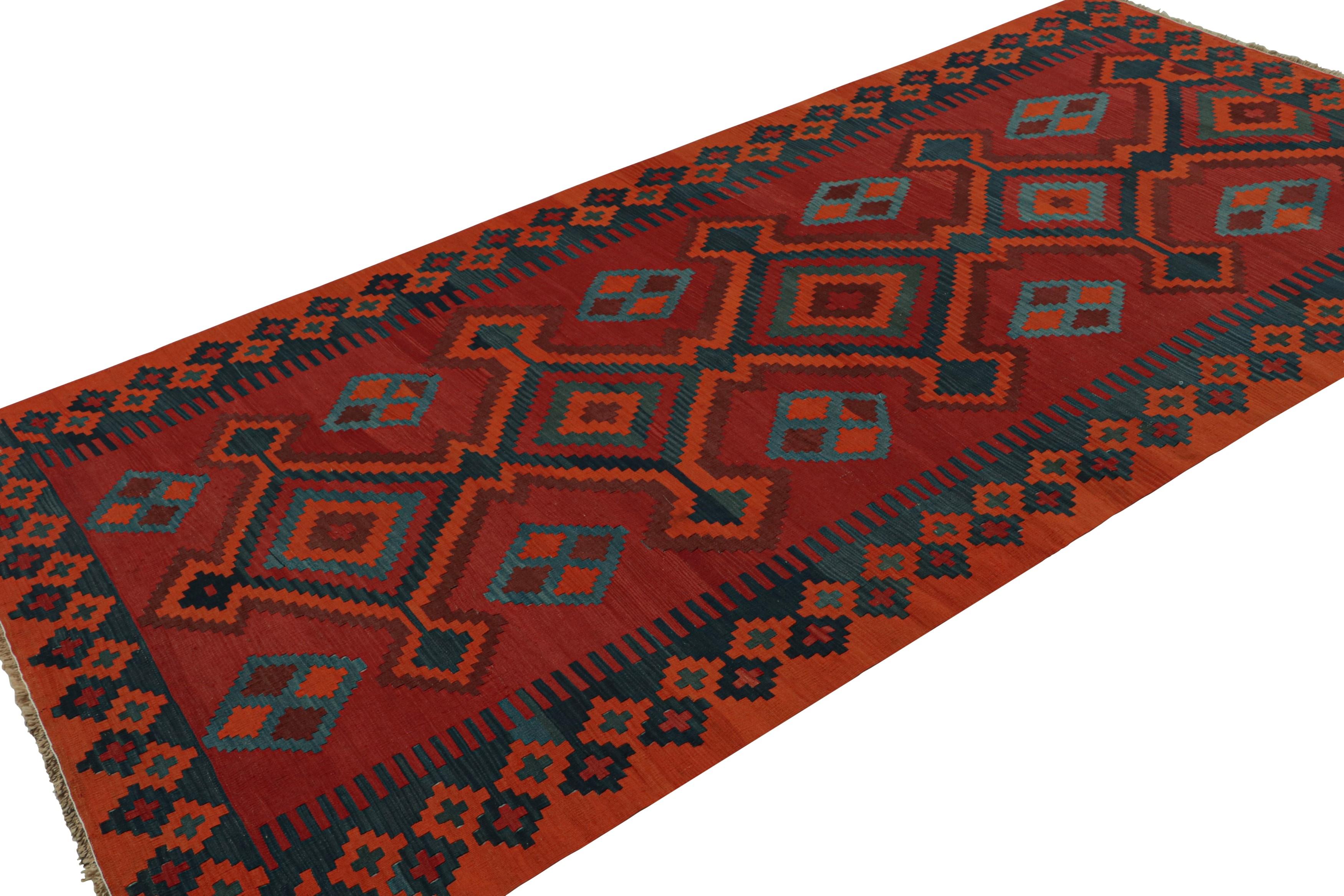 Handwoven in wool, circa 1950-1960, this 5x11 vintage tribal Afghan kilim rug features vibrant medallions and geometric patterns in blue, orange and black, on a red field. 

On the Design: 

Admirers of Afghan craft will appreciate this special
