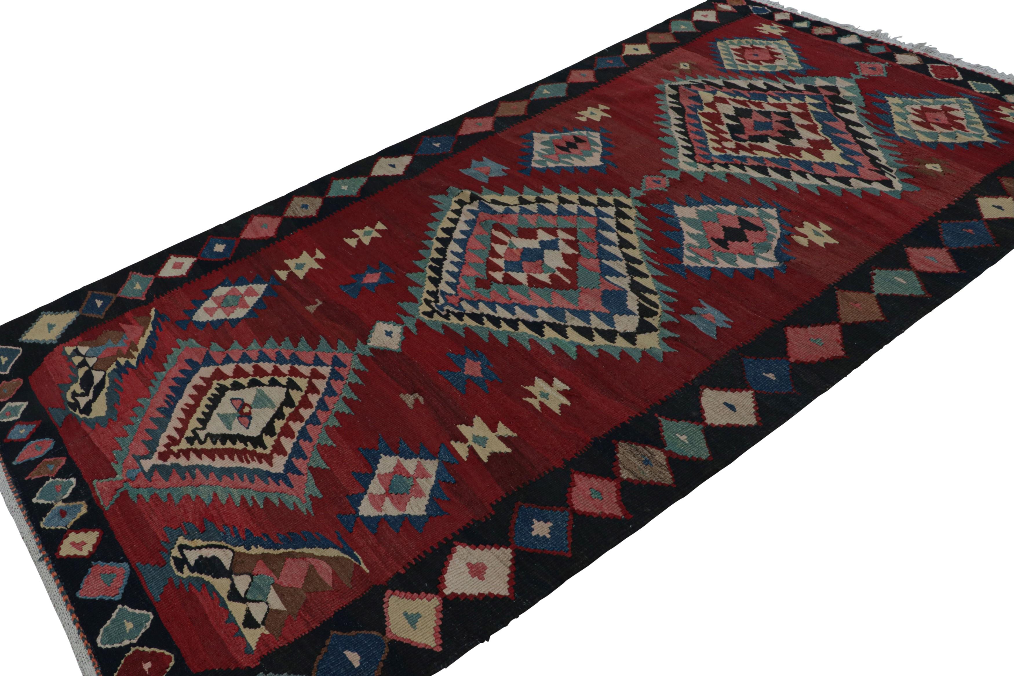 Handwoven in wool, circa 1950-1960, this 5x9 vintage tribal Afghan kilim rug features vibrant medallions and geometric patterns in blue, green and beige/brown, on a red field, and a blue border. 

On the Design:

A special piece in the Rug & Kilim