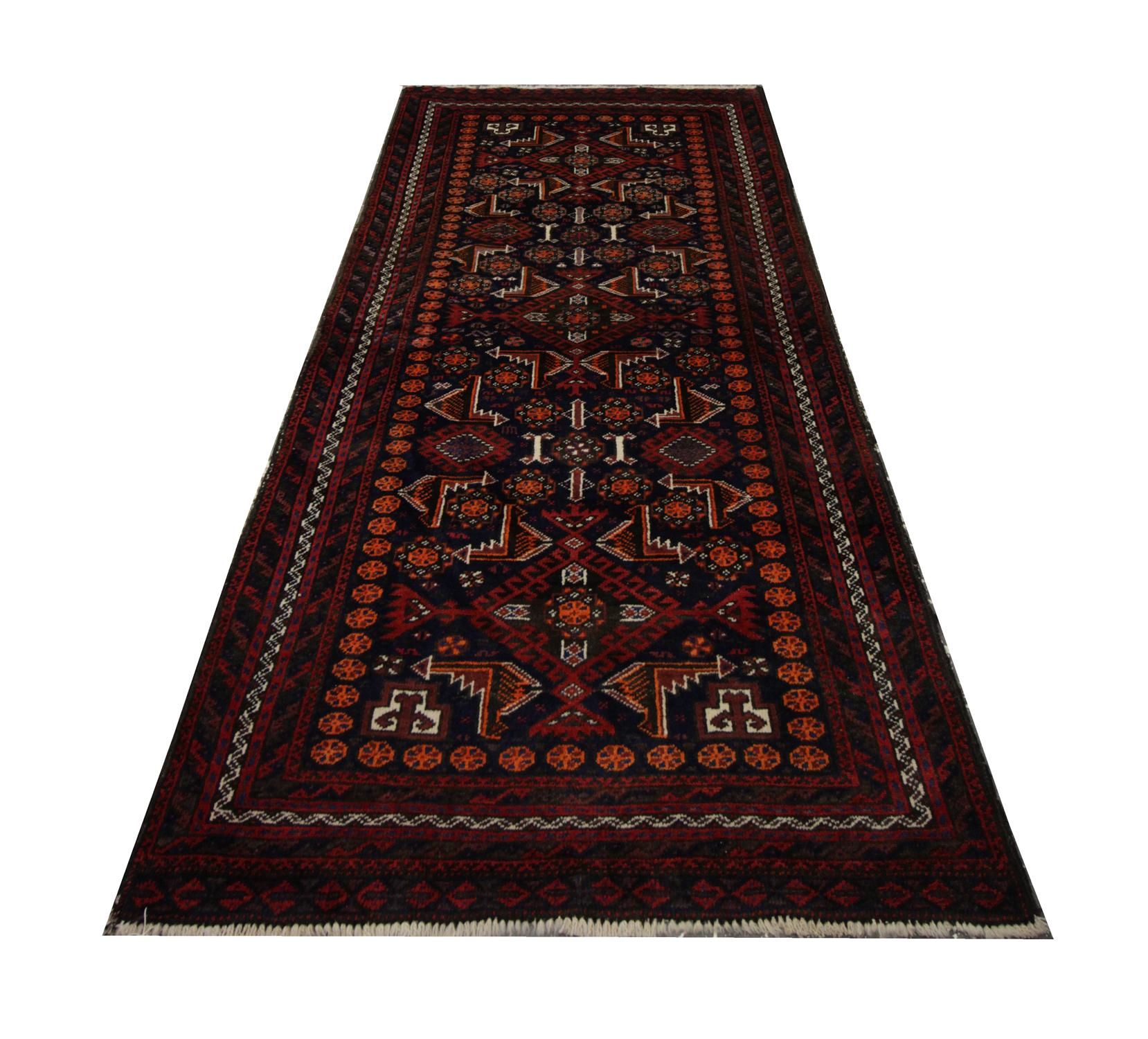 This fine wool area rug is a vintage piece woven in Afghanistan in the 1960s. The design features an intricate floral and tribal medallion design woven symmetrically in accents of orange, red and ivory. This has then been framed by a layered border