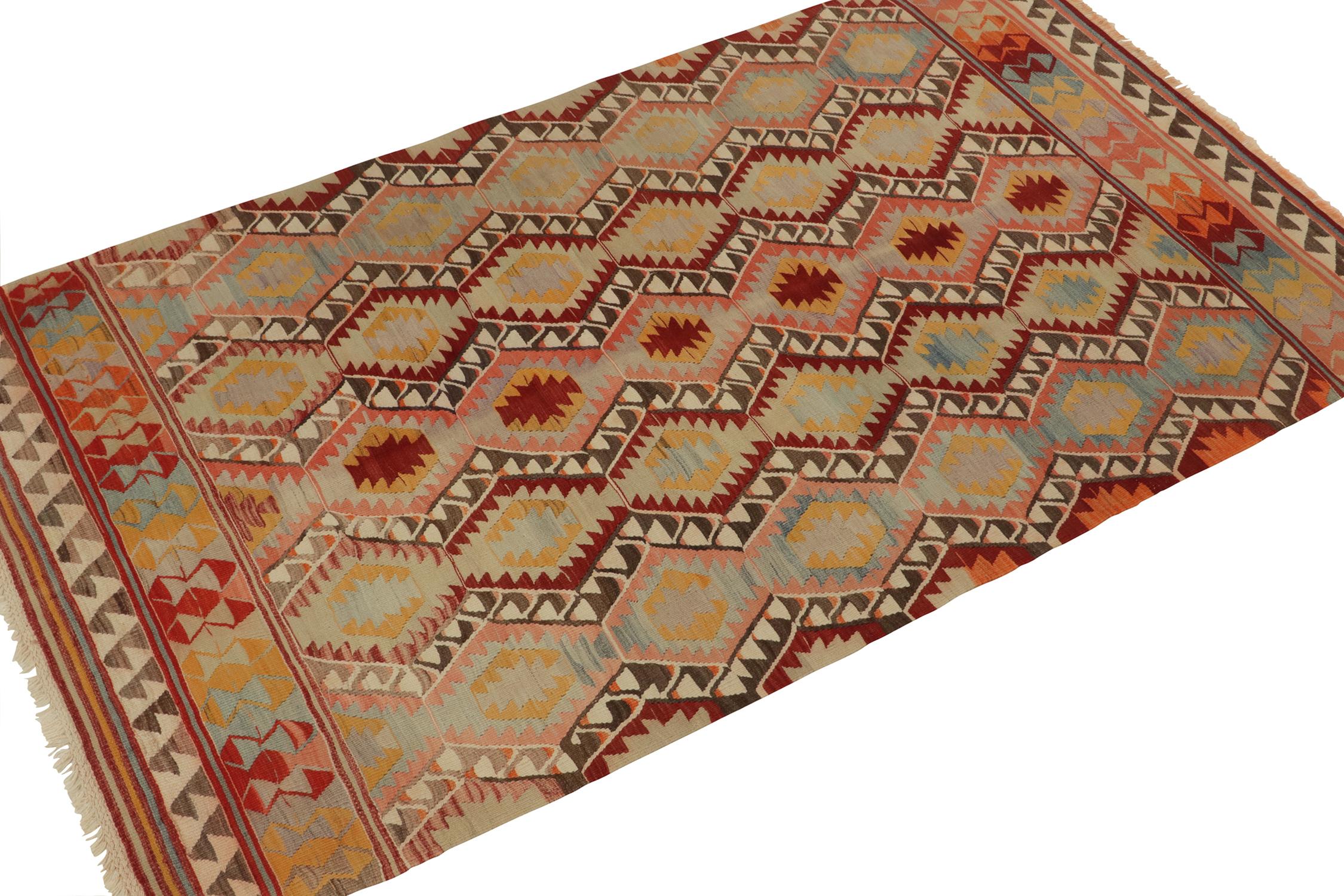 Originating from Turkey circa 1960s, a vintage tribal kilim rug capturing a playful & modern attitude for mid-century works. 

Handwoven in wool, the piece enjoys tribal patterns vibrant red, beige & gold among a polychromatic colorway. Keen eyes