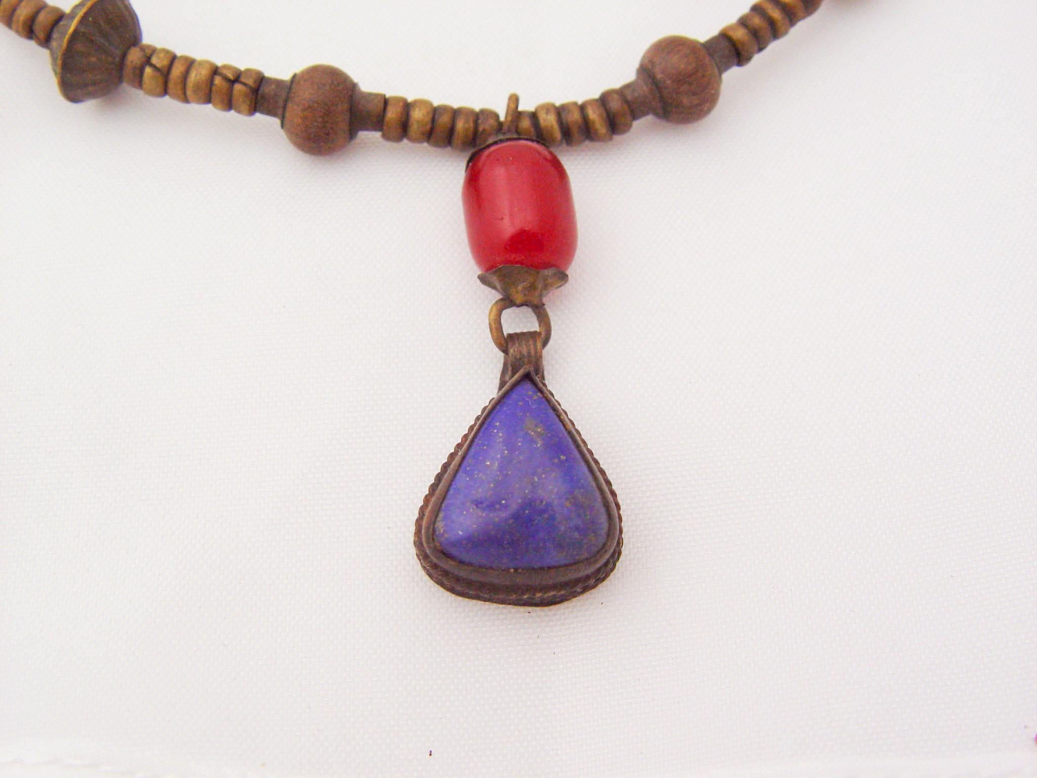 Vintage middle eastern tribal necklace. Tear drop large lapis lazuli pendent and red carnelian bead pendent and large filigree brass beads which still have traces of the original silver wash. The lapis drop is .75