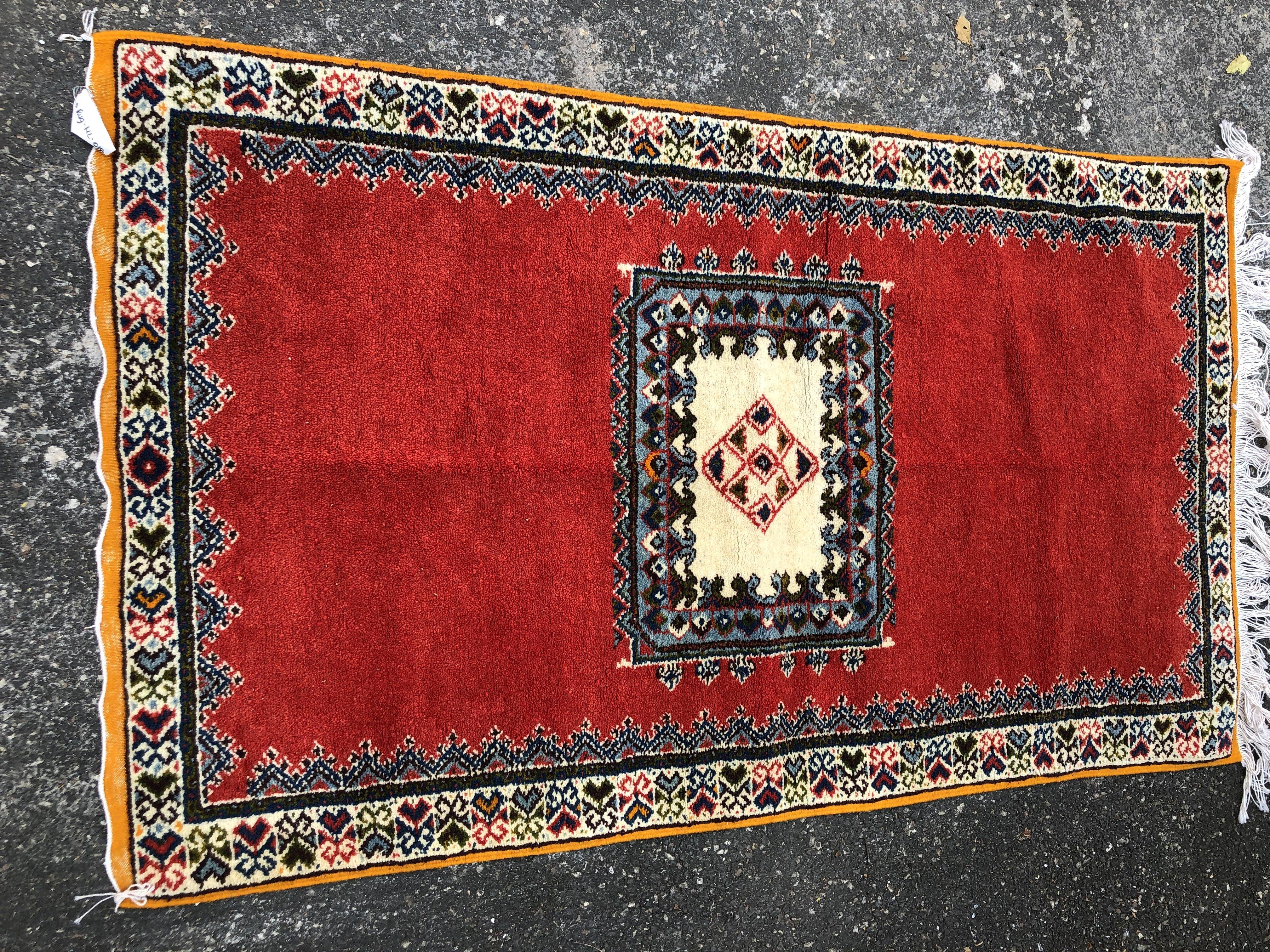 A stunning handmade vintage tribal Moroccan rectangular shaped rug featuring bold geometric patterns. The rug is finely made of high quality wool sheep and deep and vivid all natural dyes. The rug features majestic patterns with berber design motifs