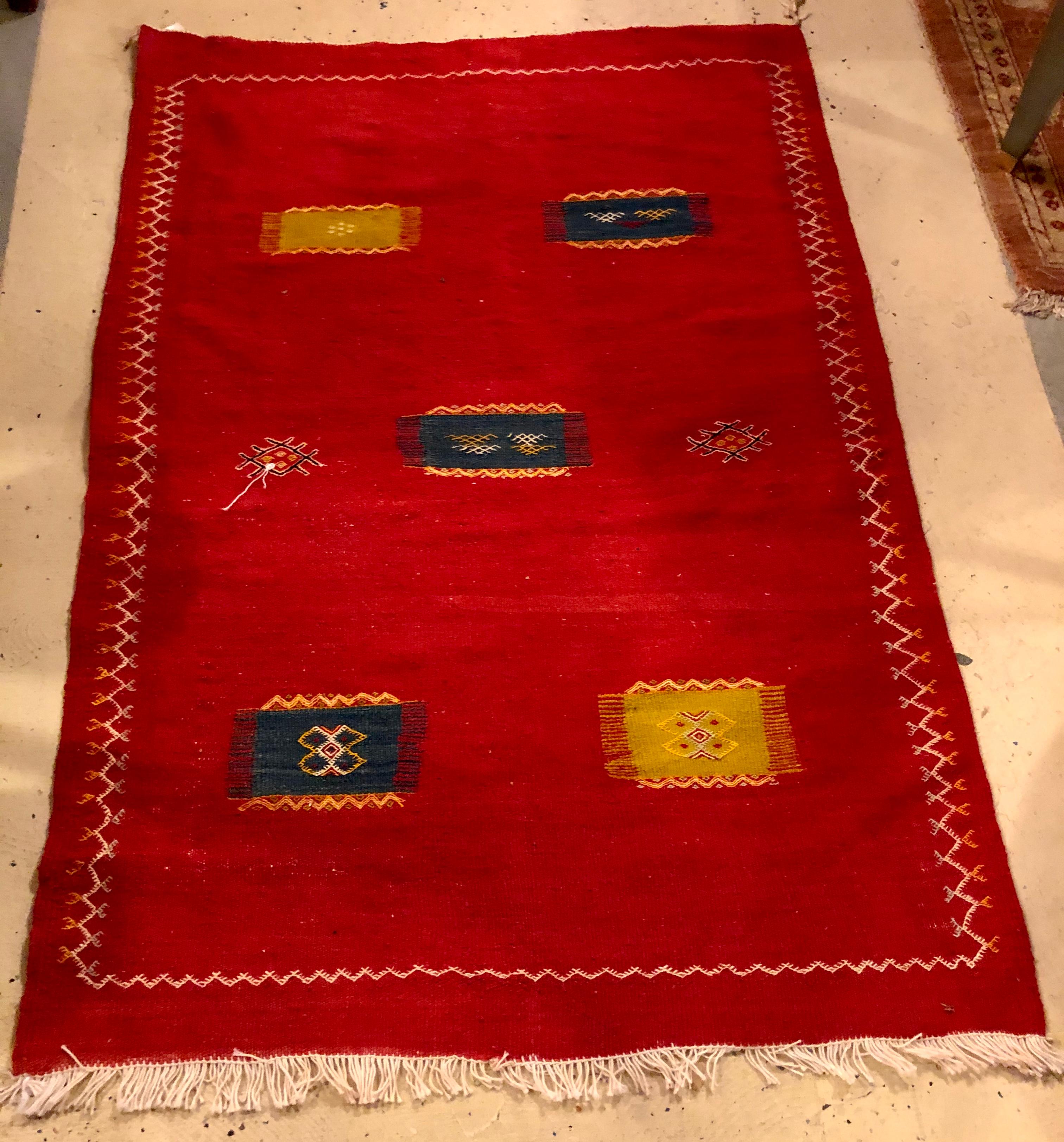 This vintage tribal Moroccan red wool rug or carpet in flat-weave style is form the berber region of the Atlas Mountains in Morocco. Made using the highest-quality 100% sheep's wool, the rug features deep and vivid all-natural vegetable dyes in red