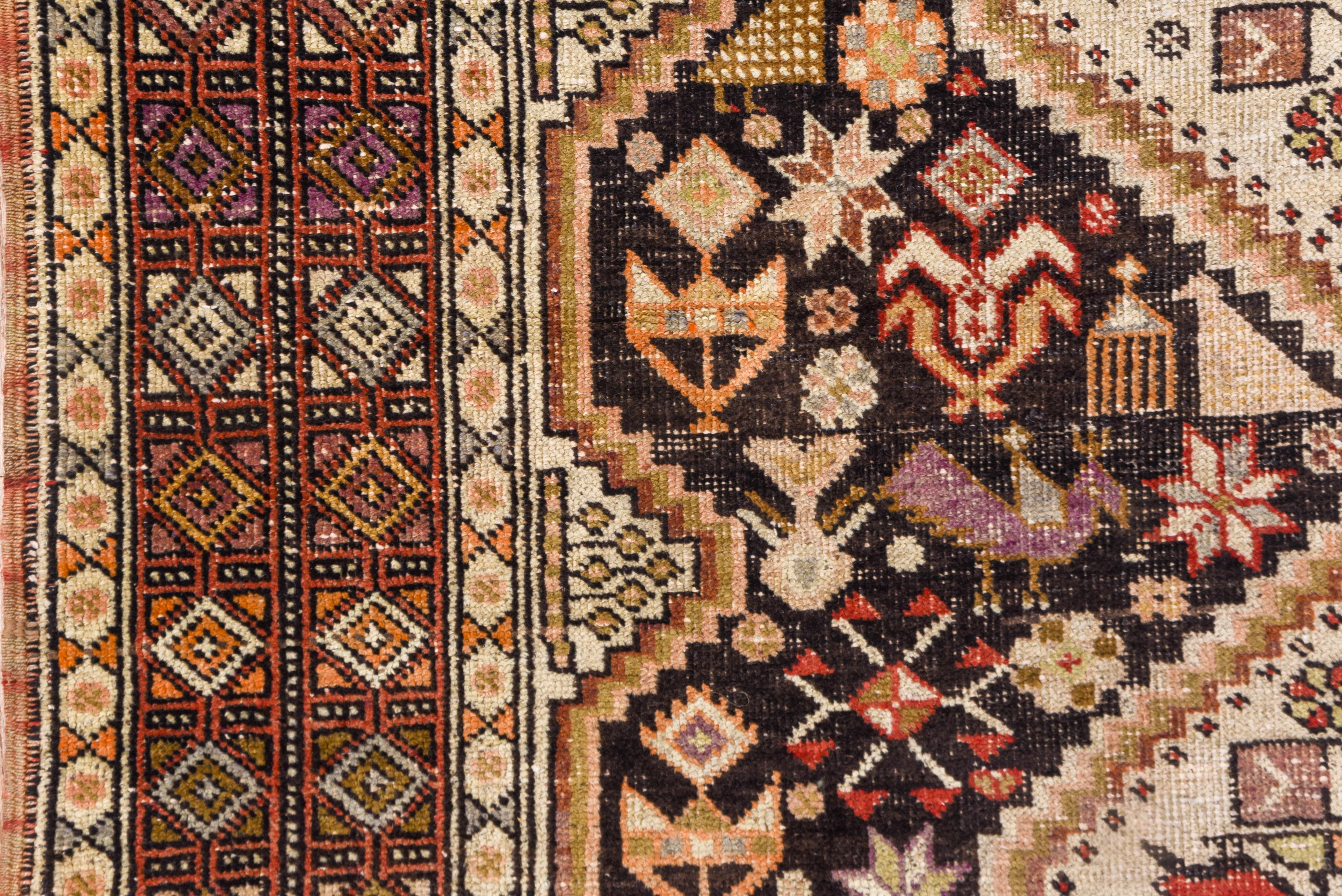 A tribal scatter with a black field with flowers and characteristic chickens, supporting a joined two hexagon ivory pole medallion accented with more small birds. Rose Turkmen-style border of two rows of small squares.