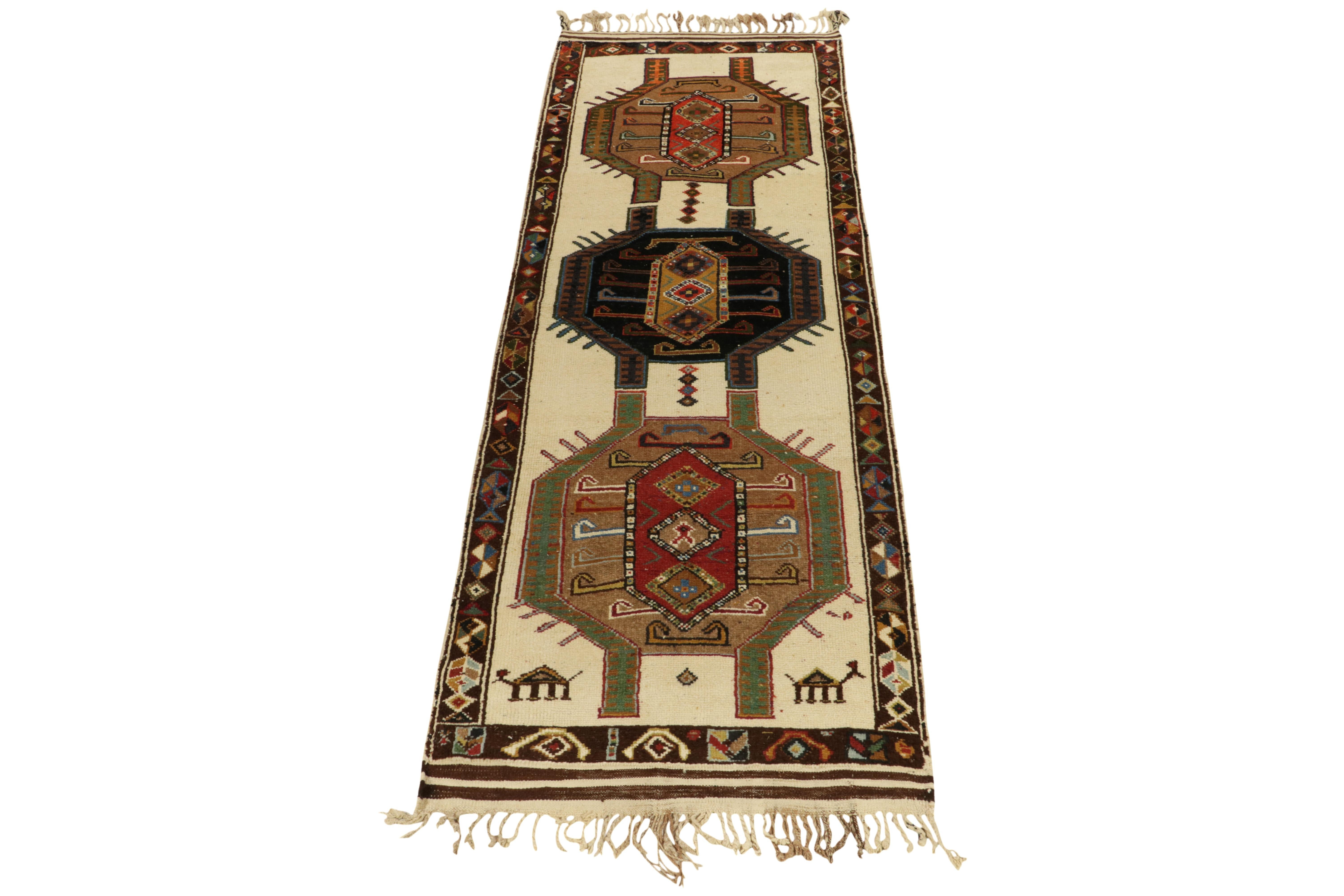 From Rug & Kilim’s vintage selections, a 4x12 hand-knotted wool rug from Turkey bearing graphic, colorful Nomadic attitude. 

The 1950s tribal piece showcases traditional motifs on the field in beige-brown, with red, green and black further
