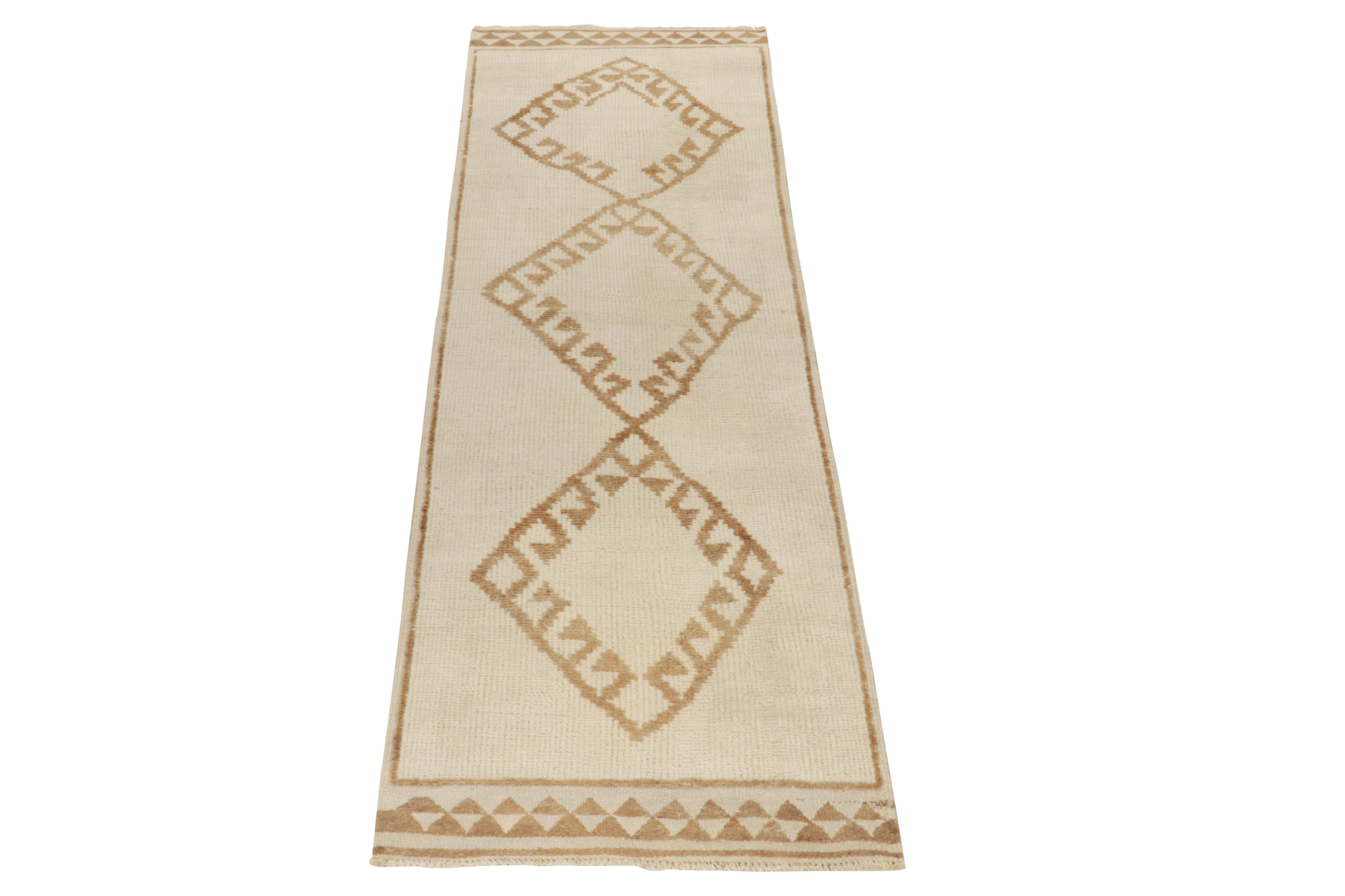 From Rug & Kilim’s vintage selections, a 3x11 hand-knotted wool runner carrying nomadic inspiration. The 1950s tribal piece showcases diamond medallions in latch hooks sitting peacefully on the off-white field in a beige-brown colorway further