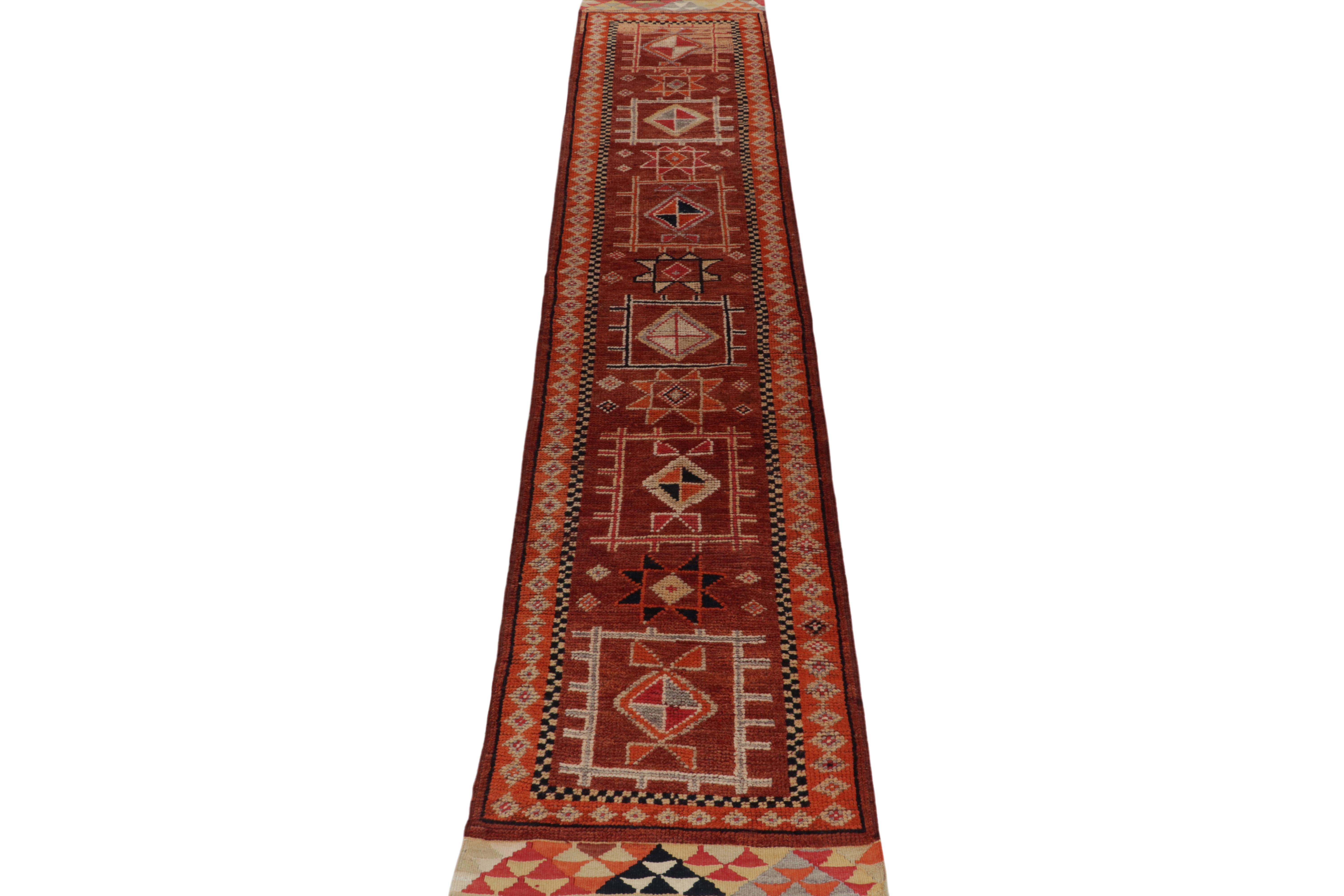 From a rare new curation by Rug & Kilim, a 3x14 vintage tribal runner, hand-knotted in wool circa 1950-1960.

Tasteful & inviting tones of rust red, orange & brown enjoy black accents in a series of classic medallions and similar geometric
