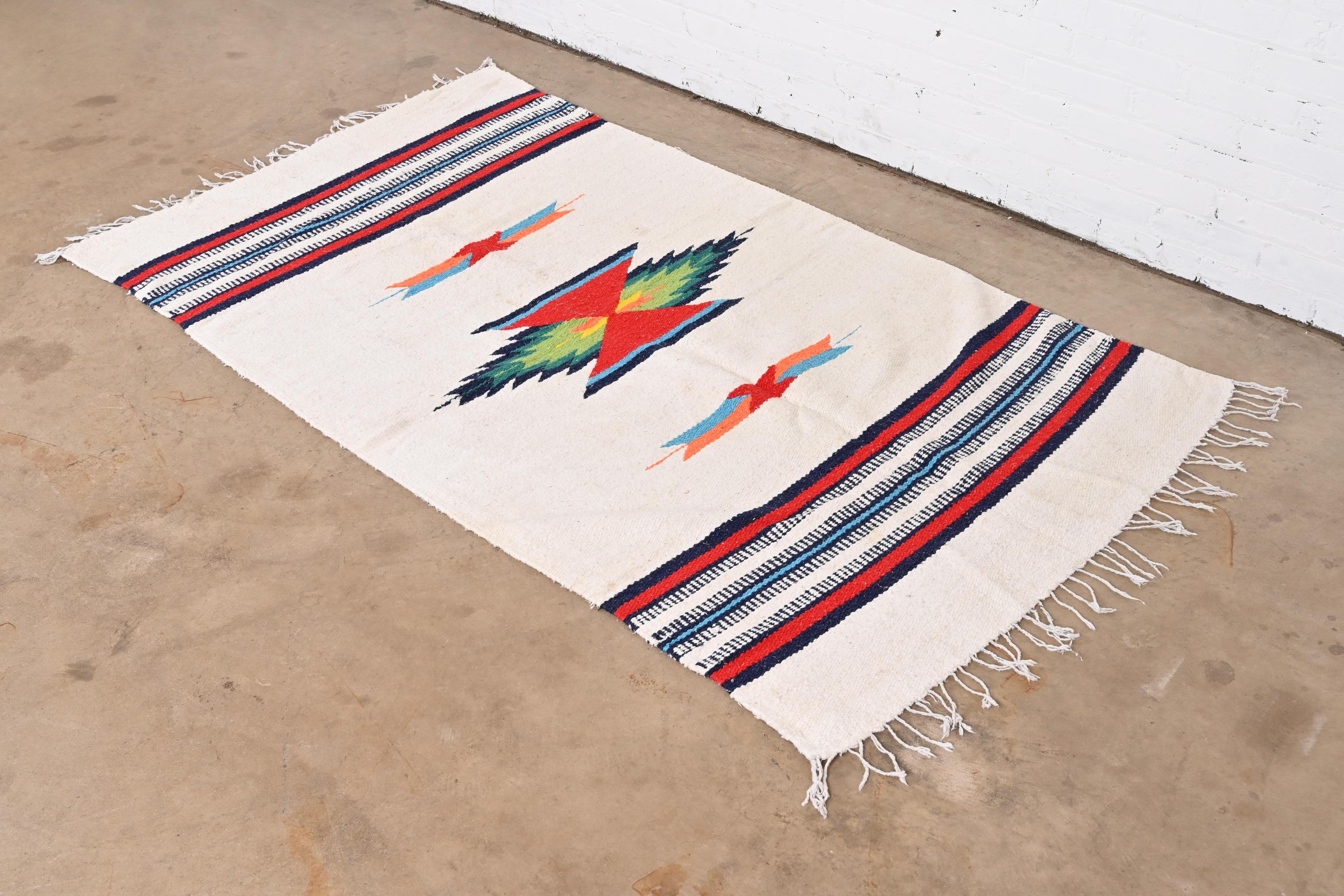 A gorgeous vintage tribal Southwest Navajo style wool rug

USA, Mid-20th Century

Beautiful geometric design, with predominant colors in ivory, red, blue, yellow, and green.

Measures: 43