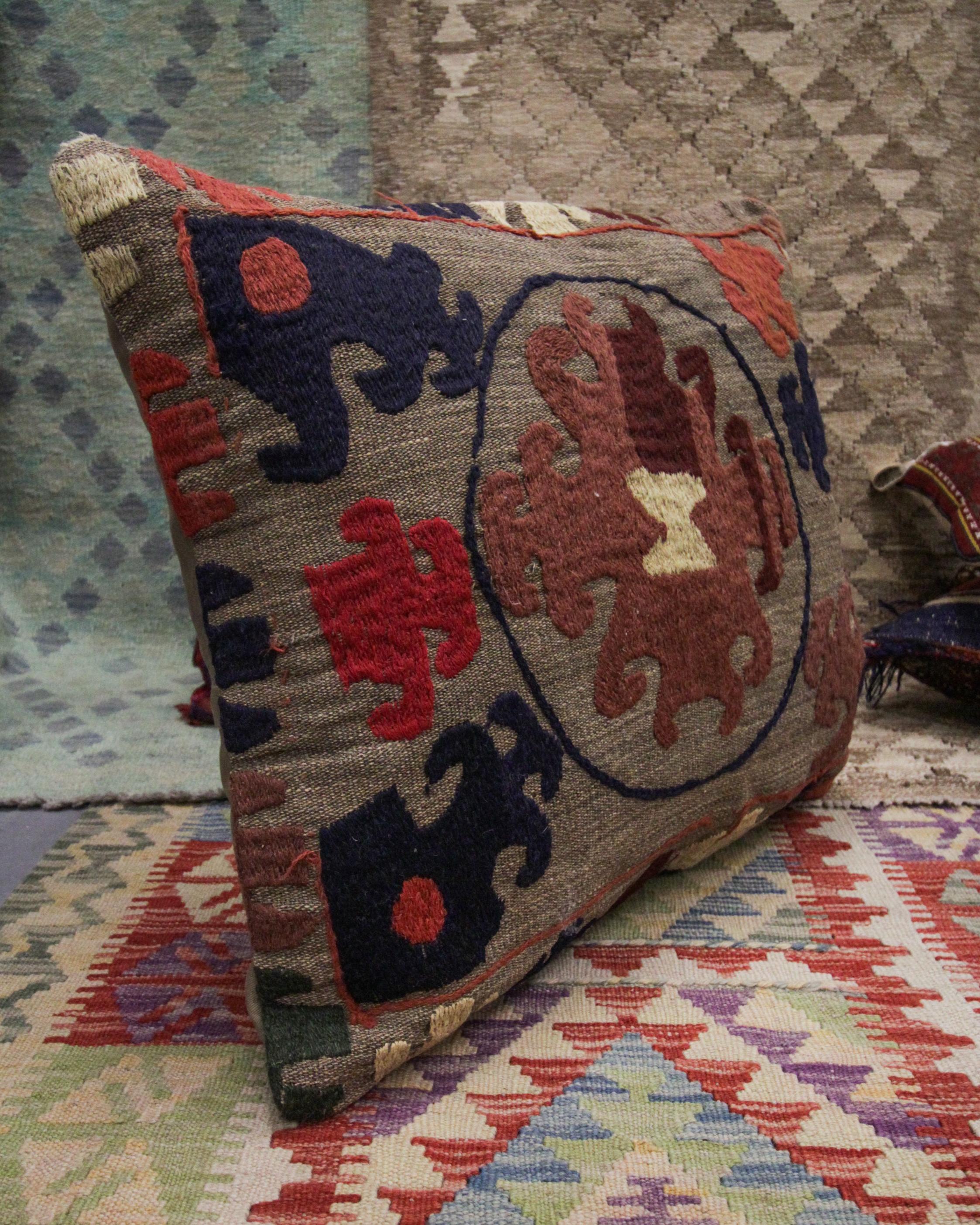 This truly unique tribal cushion cover is a larger piece suited to a bed or a sofa. Woven with a one of a kind tribal motif pattern in accents of brown, beige and deep blue on a beige-brown background. This cushion's colour palette and tribal design