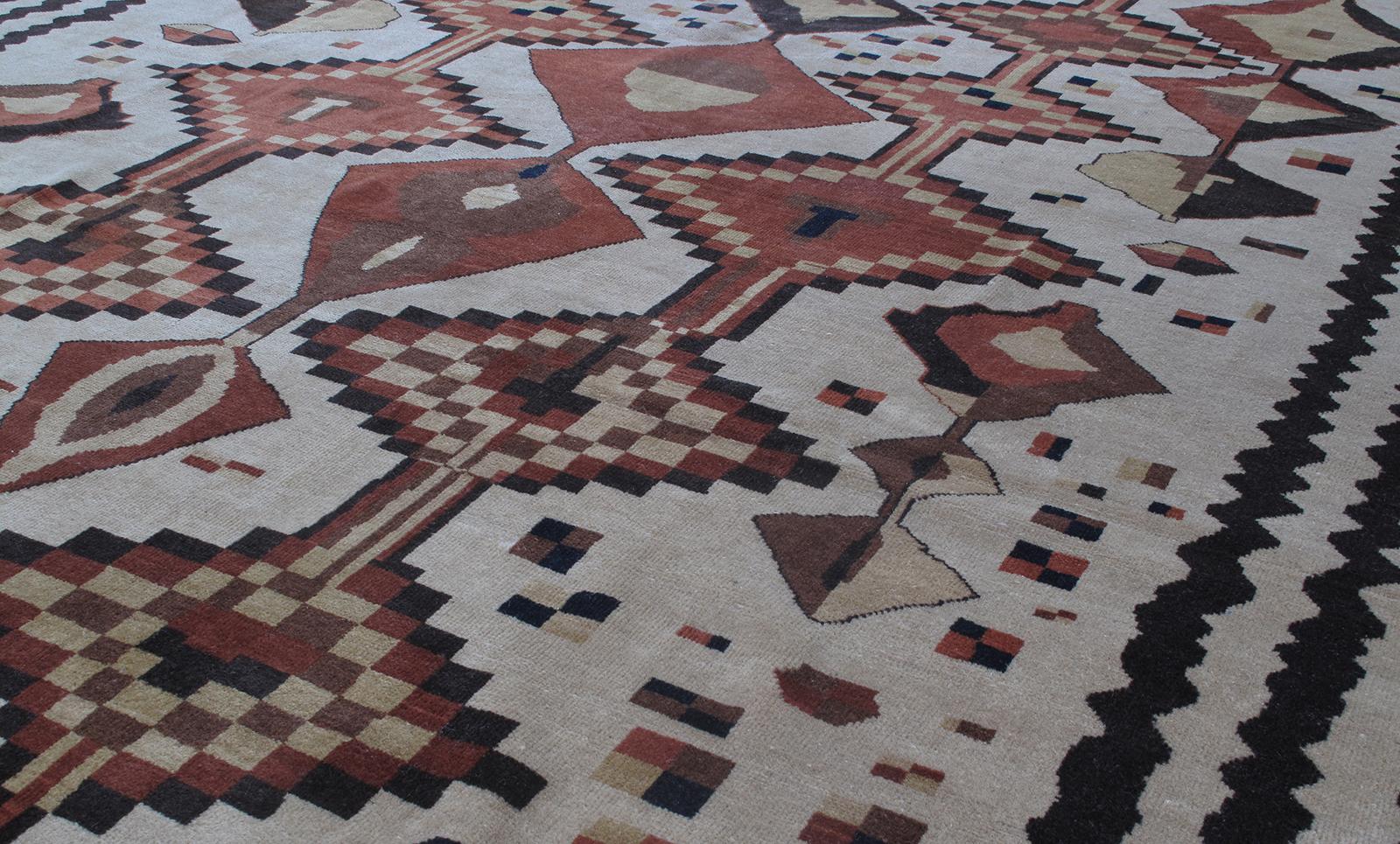 Ce tapis turc tribal vintage présente un motif inhabituel et asymétrique enfermé dans une double bordure. Il est noué à la main avec 100% de laine et des teintures végétales naturelles sont utilisées. Ce tapis présente des similitudes avec les tapis
