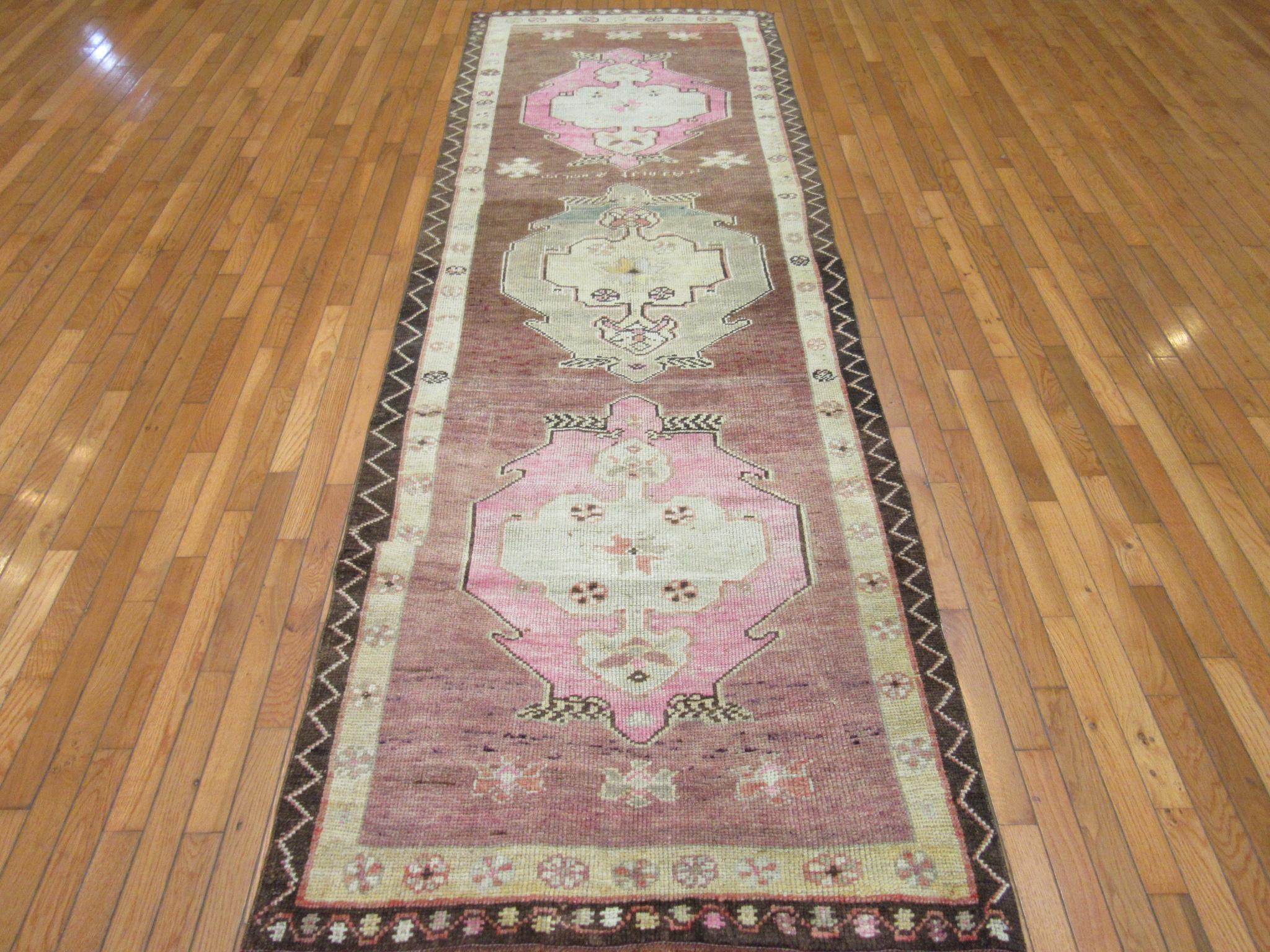 This is a vintage hand-knotted Turkish runner rug from the Anatolian region. It is made with wool in a simple tribal pattern. This runner would enhance the look of any hall or space. It measures 3' 5'' x 10' 8'' and in great condition.