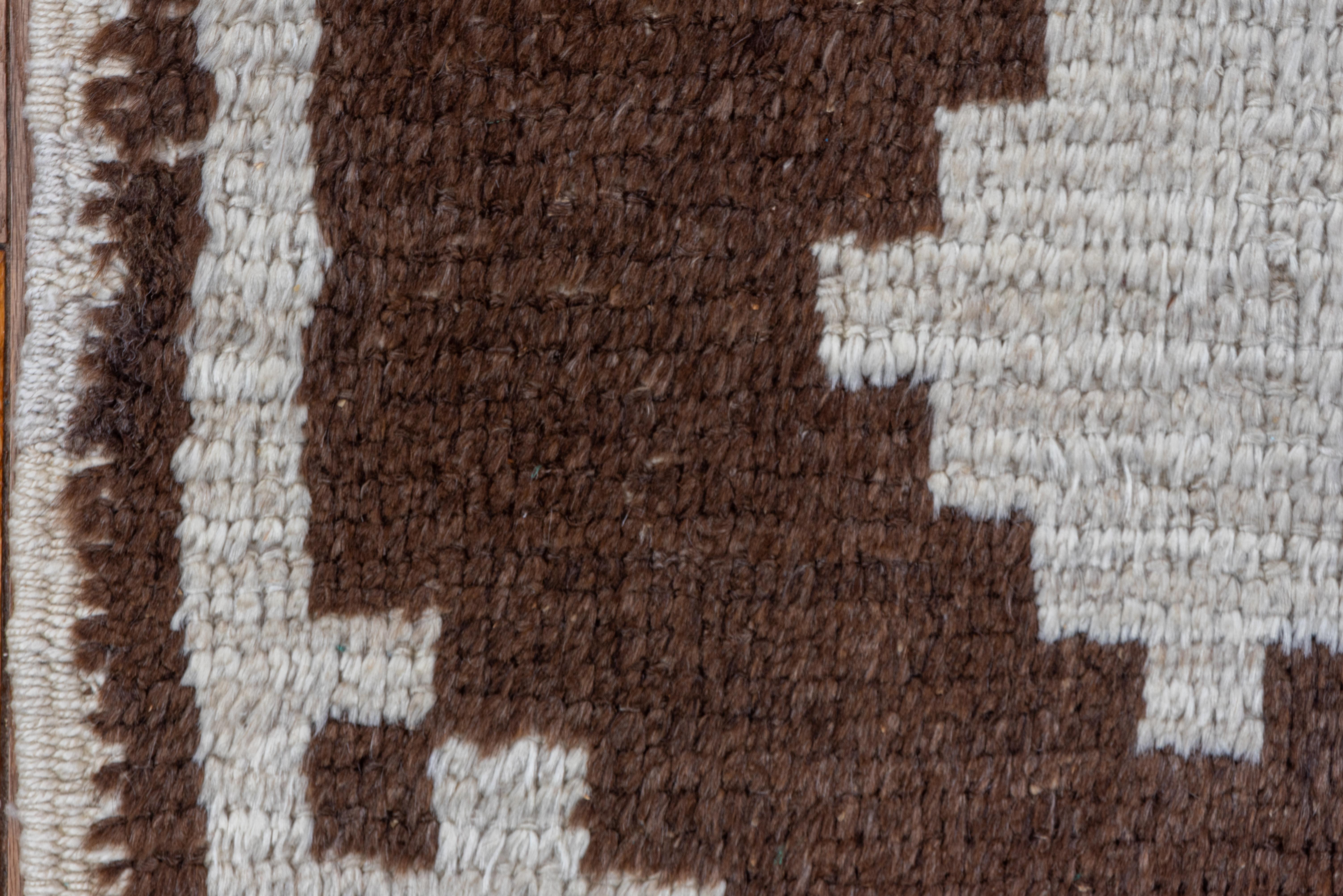 This bold two-tone rustic Turkish Tulu scatter rug has a triple arrowhead fcoss pattern with one device substantially squeezed at one end. Stepped drawing looks like a needlepoint. Brown and ivory tonality.