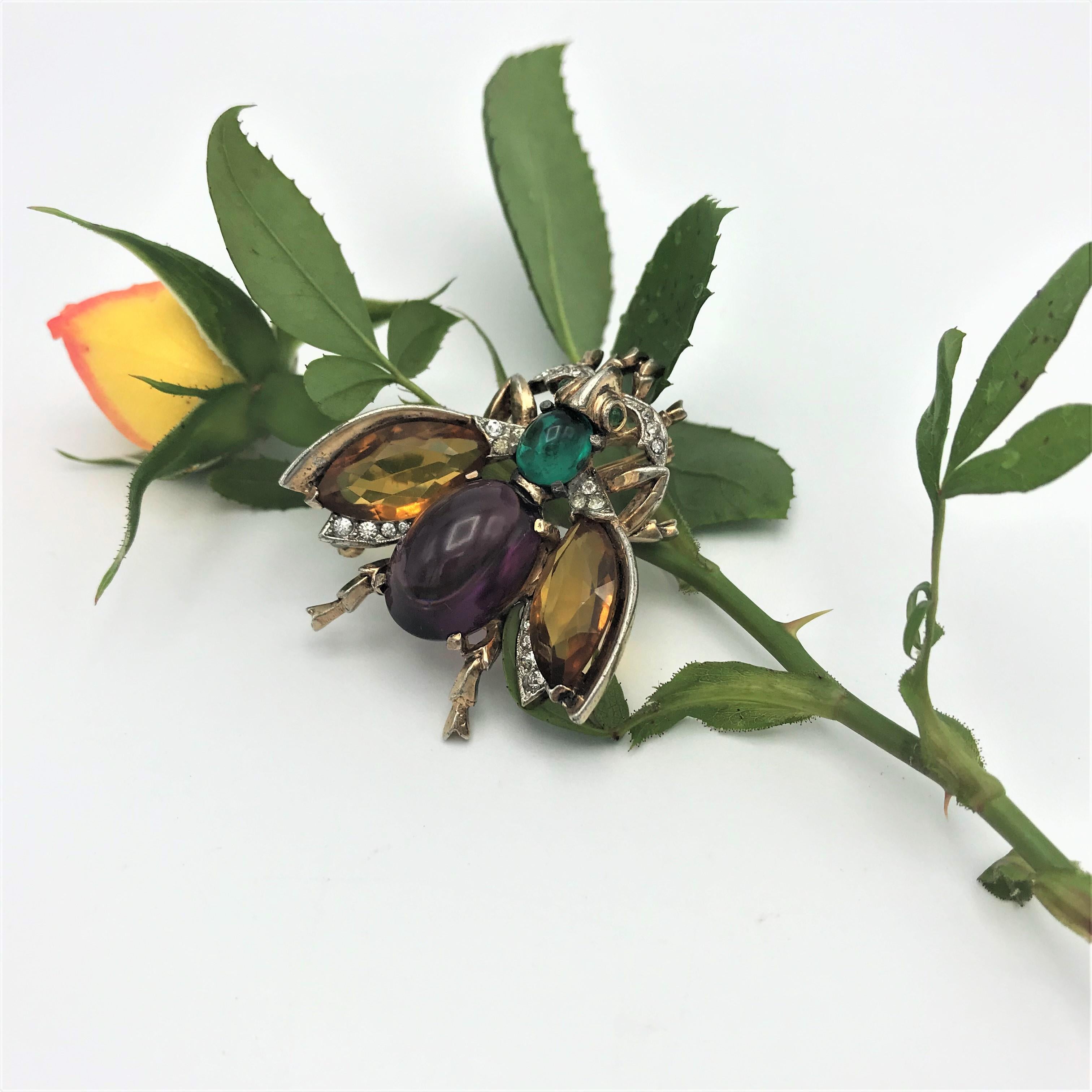 Vintage Trifari brooch in the shape of a bee with cut rhinestone wings, the body of purple and green rhinestones and small clear rhinestones distributed around the body.
Measurement: Length 4,5 cm1,77