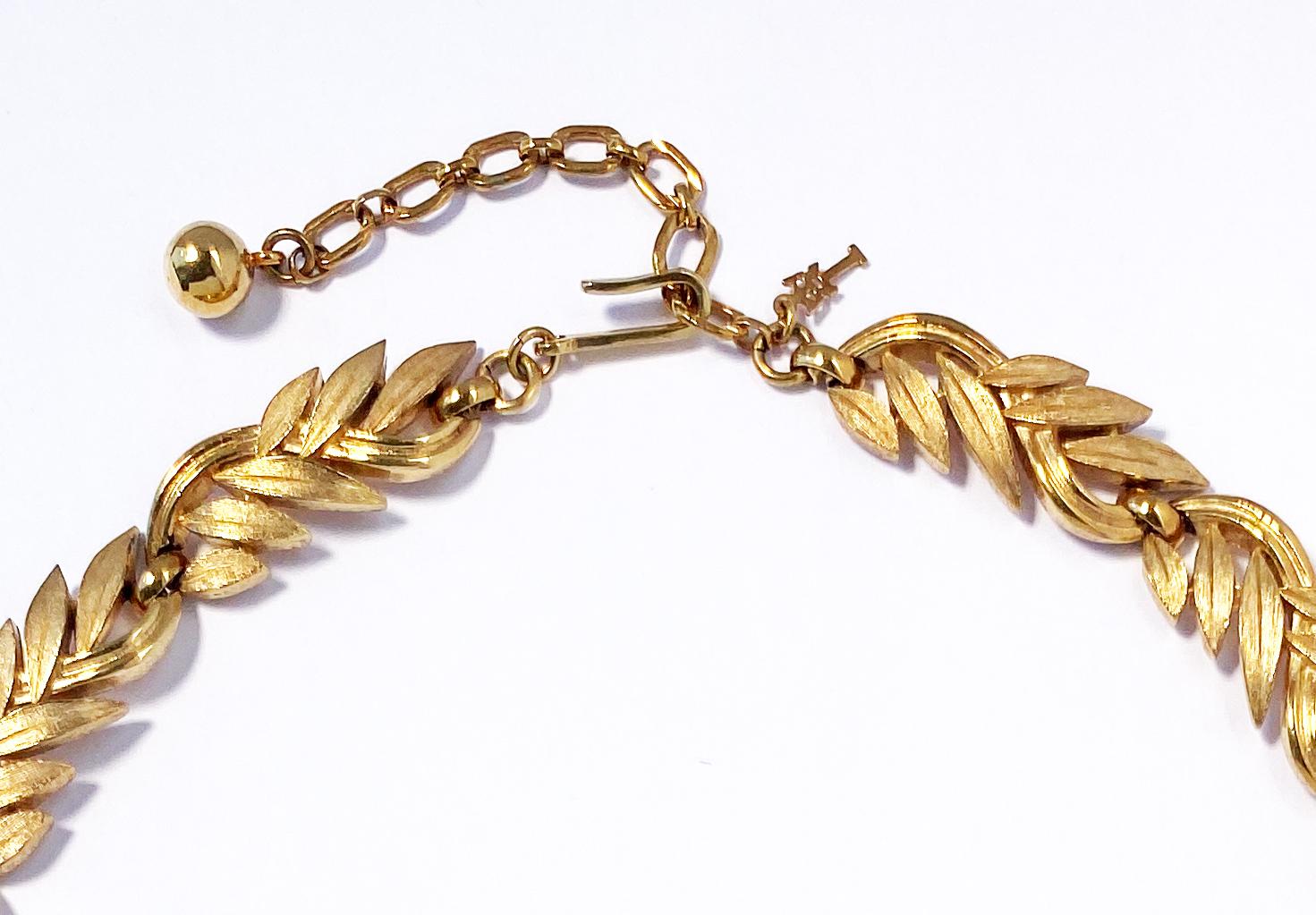 Vintage 1960s Trifari botanical motif leaf necklace in gold plate.  This collar-style heritage necklace comprises an interlocking leaf and stem design featuring a combination of brushed and high-polish finishes for an appealingly tactile effect. 