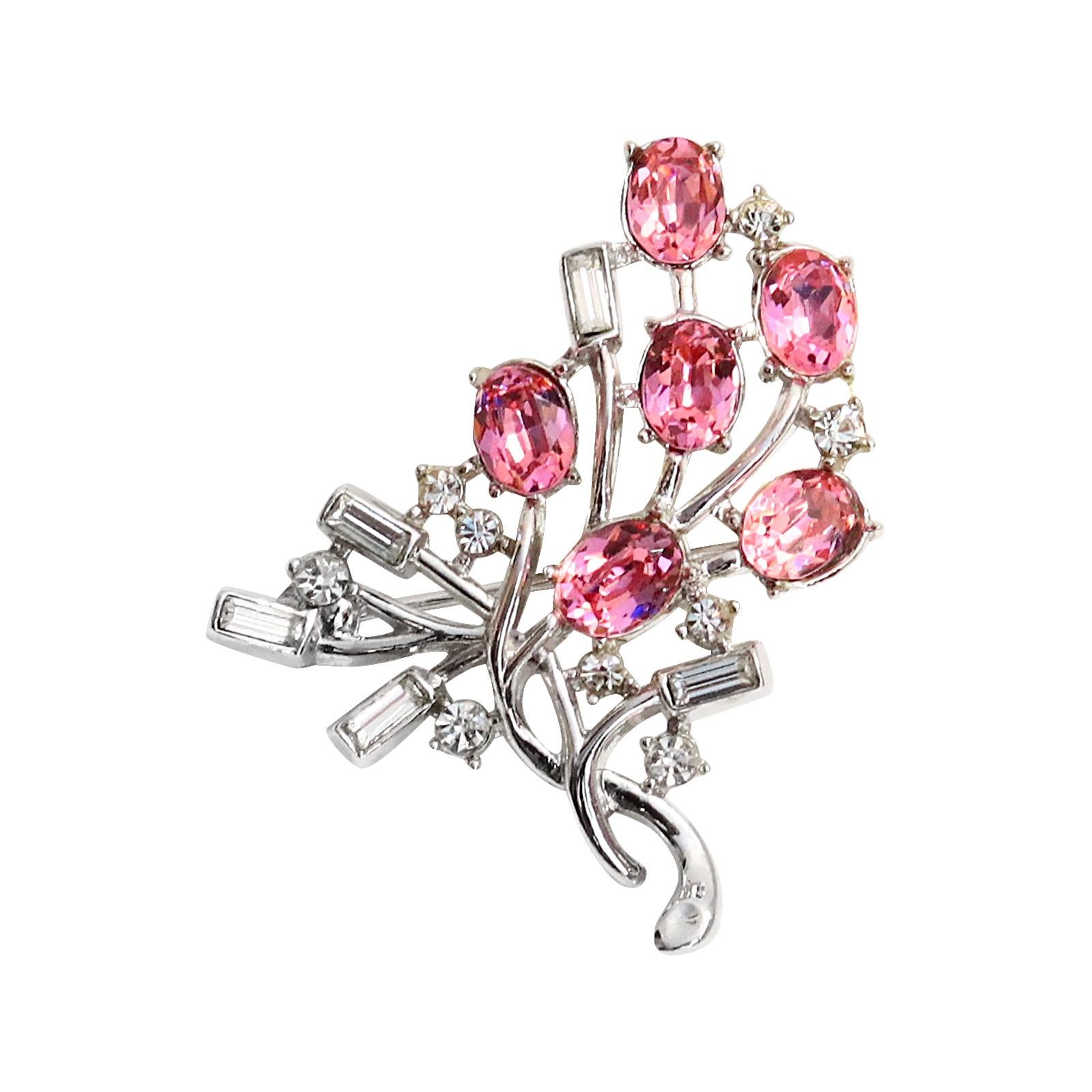 Vintage Trifari Diamante Pink and Baguette Brooch Circa 1960s.  Looks like Flowers wrapped around a vine. The flowers are represented by oval shaped pink stones that are interspersed by small round stones and then the leaves are represented by