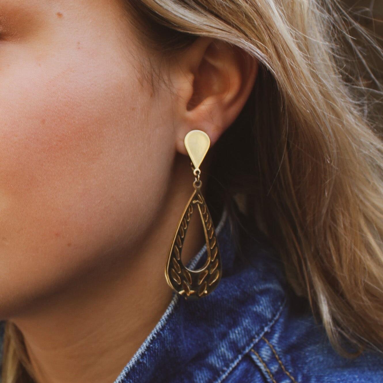 Ces superbes boucles d'oreilles, fabriquées aux États-Unis en métal doré, sont l'incarnation de l'élégance intemporelle. Elles proviennent de l'une des marques de bijoux fantaisie les plus prisées au monde,

Trifari. Fondée en 1918 par l'immigrant