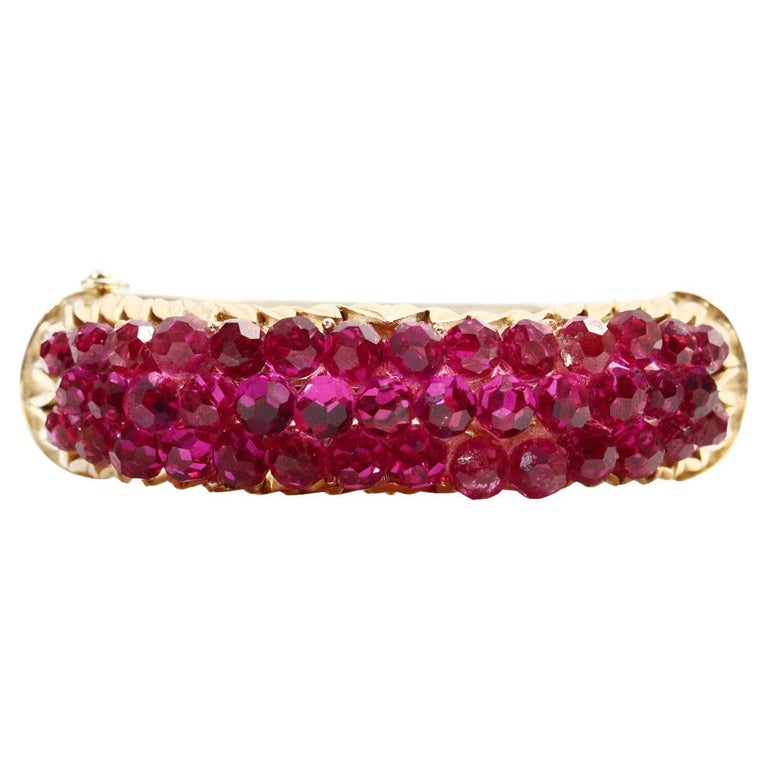 Vintage Trifari Gold Tone Bracelet with Pink Beads. Oval fitting bracelet with lots of fuscia beaded pieces gathered together at the top. Well made and substantial. Alone or mixed with other pieces it will be a stand out. This bracelet matches the
