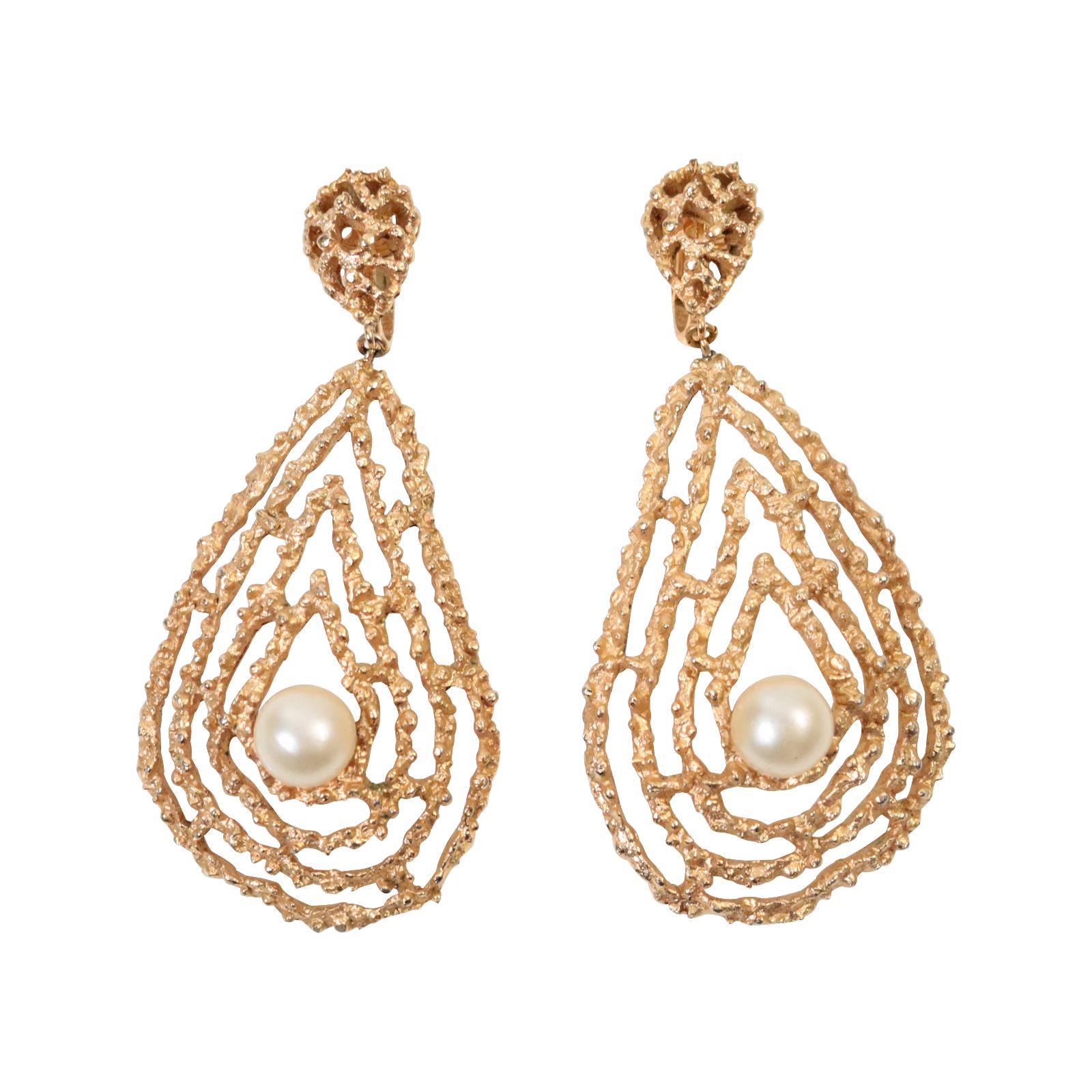 Vintage Trifari Gold Tone With Faux Pearl Earrings Circa 1980s. The earrings feature a slightly built-up 3D tear-drop shape with a brutalist gold tone composition, but with a faux pearl in the center, which lends this shape incredible softness. Clip