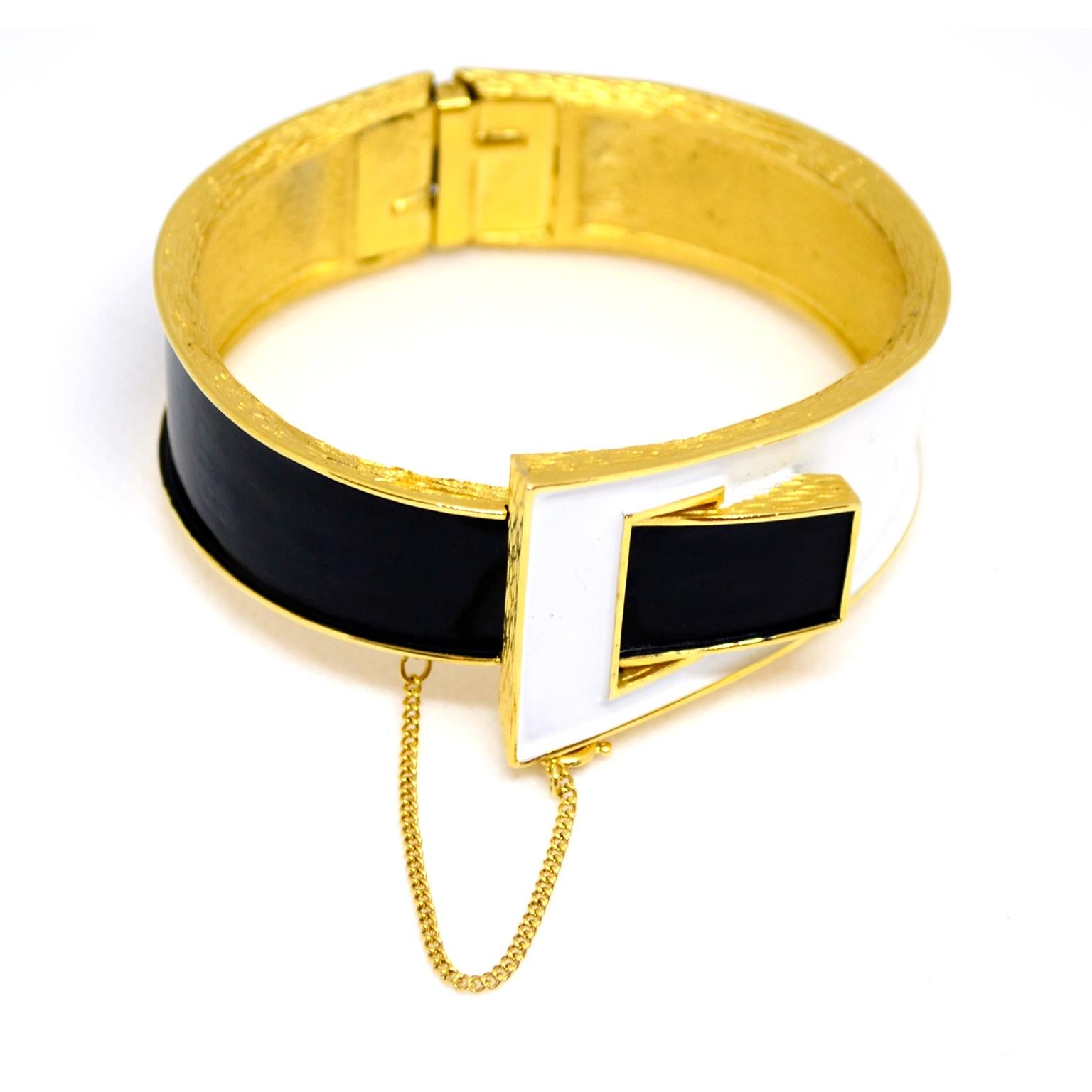 This is a great vintage Trifari clamper bracelet with white and black enamel on gold tone metal. The hinged bracelet resembles a buckle and measures 6.5