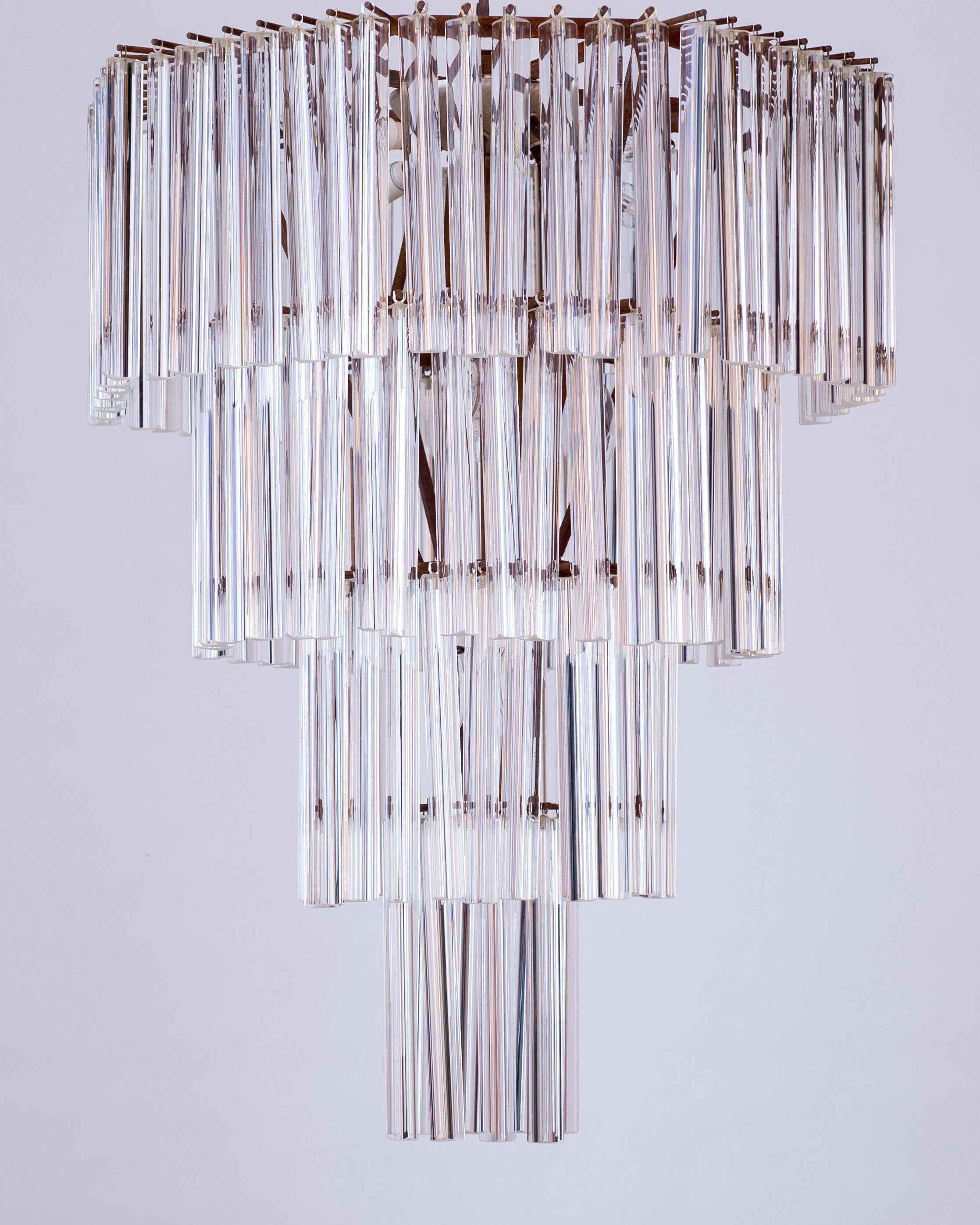 Vintage trihedron chandelier in Murano glass, attributed to Venini, 1970s.
The octagonal framework supports four rows of transparent Murano glass trihedrons that filter and reflect the light coming from 11 light bulbs. Each trihedron is hanging
