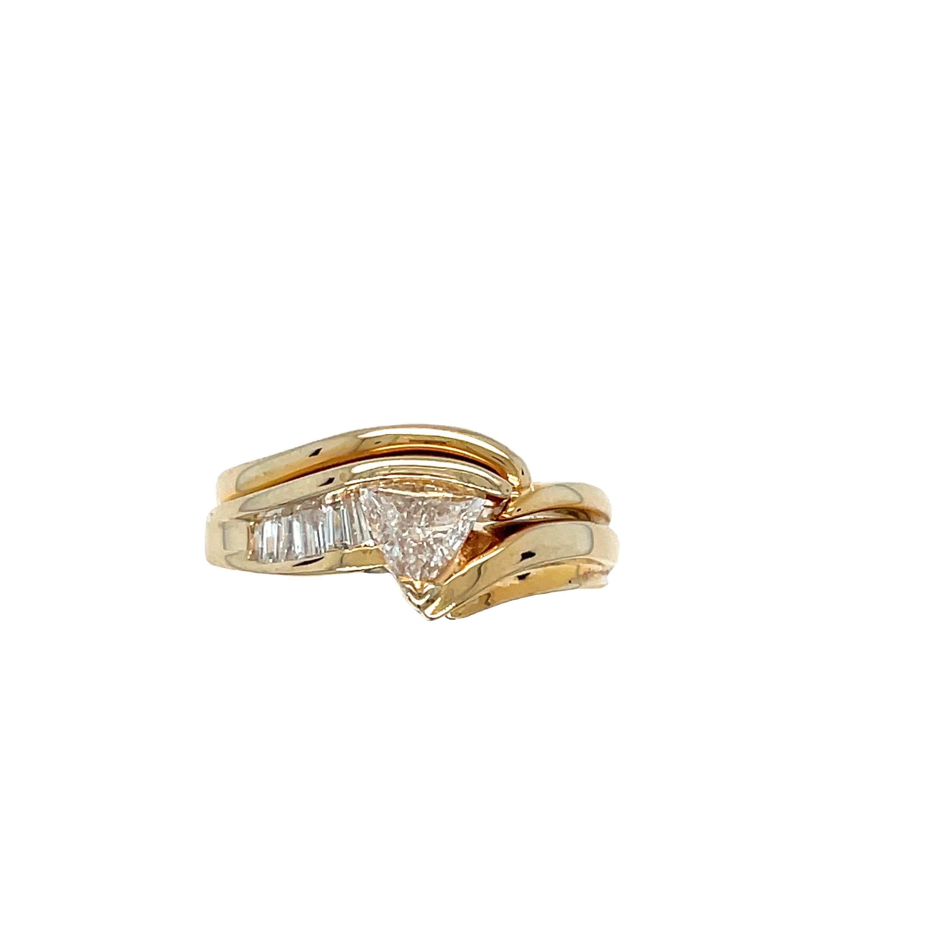 This stylish vintage ring is made of 14k yellow gold and features a sleek design. It showcases a beautiful trillion cut diamond at the center, estimated to be 0.45 carat, surrounded by double swirls. The side of the ring is adorned with a channel