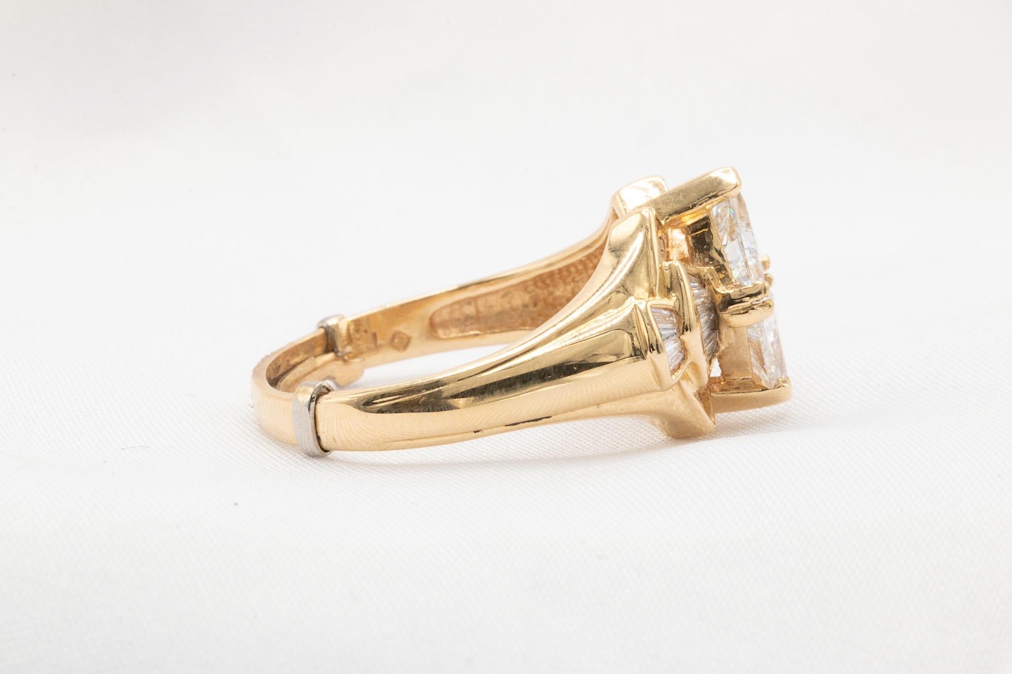 For collectors and enthusiasts of vintage diamond jewelry, this 14k yellow gold ring is a true standout with its unique and captivating design. The ring features approximately 1.38 carats of diamonds, including two striking center trillion diamonds,