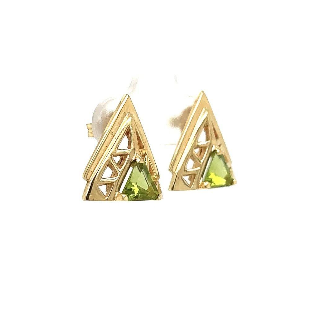 Simply Beautiful! Vintage Finely detailed Trillion Peridot in Gold Triangle Post Earrings. Securely Hand set with Trillion Peridot, weighing approx. 0.80tcw. Beautifully Hand crafted 14K Yellow Gold mounting. More Beautiful in real time! Sure to be