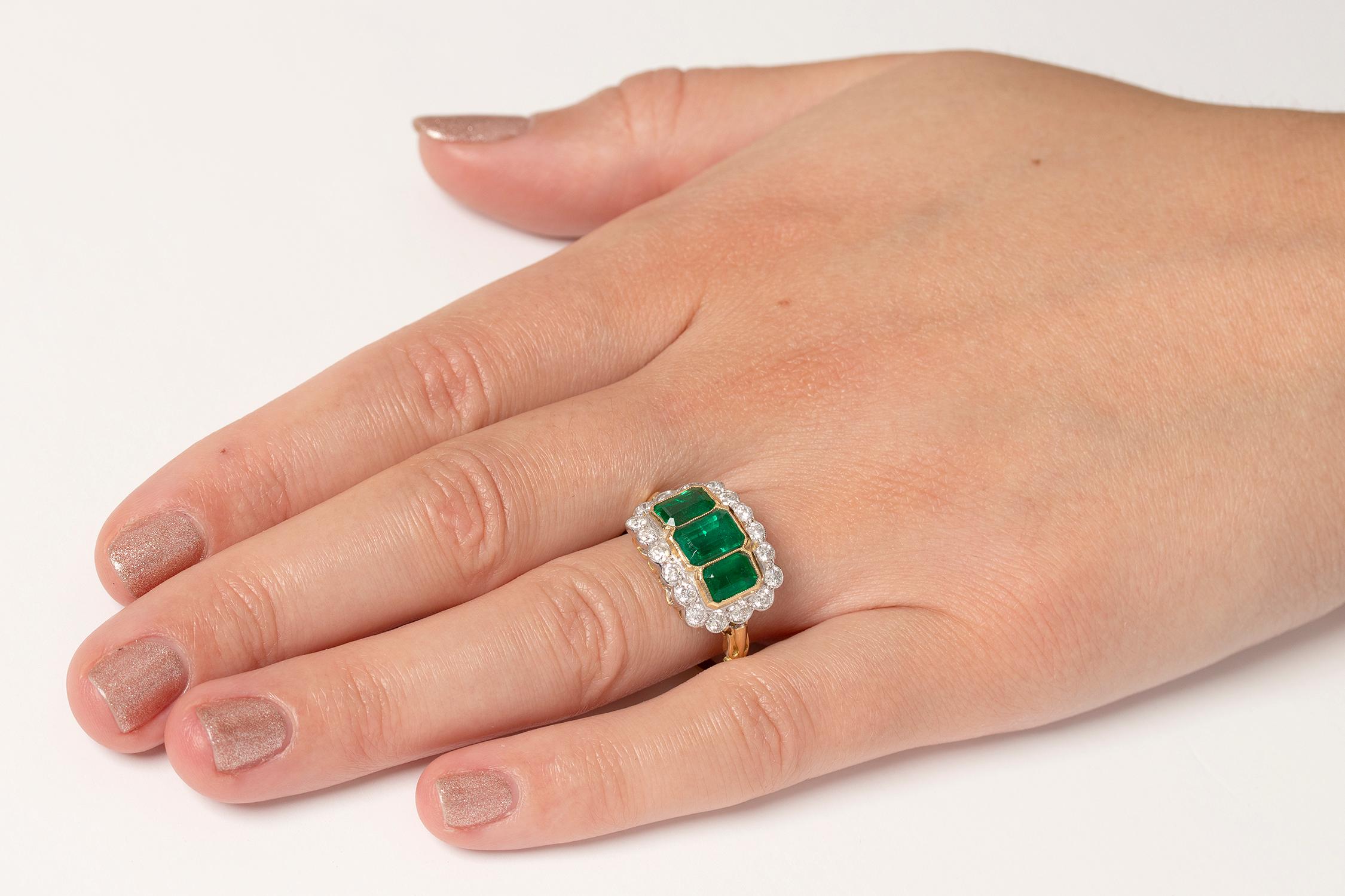 Emerald Cut Vintage Trilogy Emerald and Diamond Halo Ring, circa 1950s For Sale