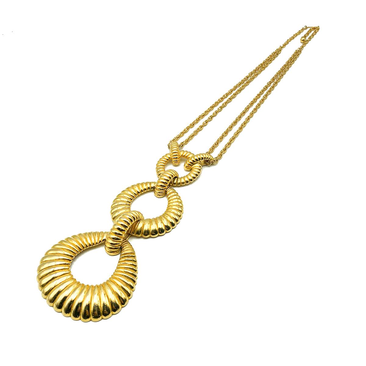 Una collana vintage a triplo cerchio sautoir assolutamente rock, risalente agli anni '60. Un trio di favolosi cerchi a coste si intrecciano per creare una goccia d'effetto dalla catena a maglie fantasia. Qualità straordinaria. Ottime condizioni