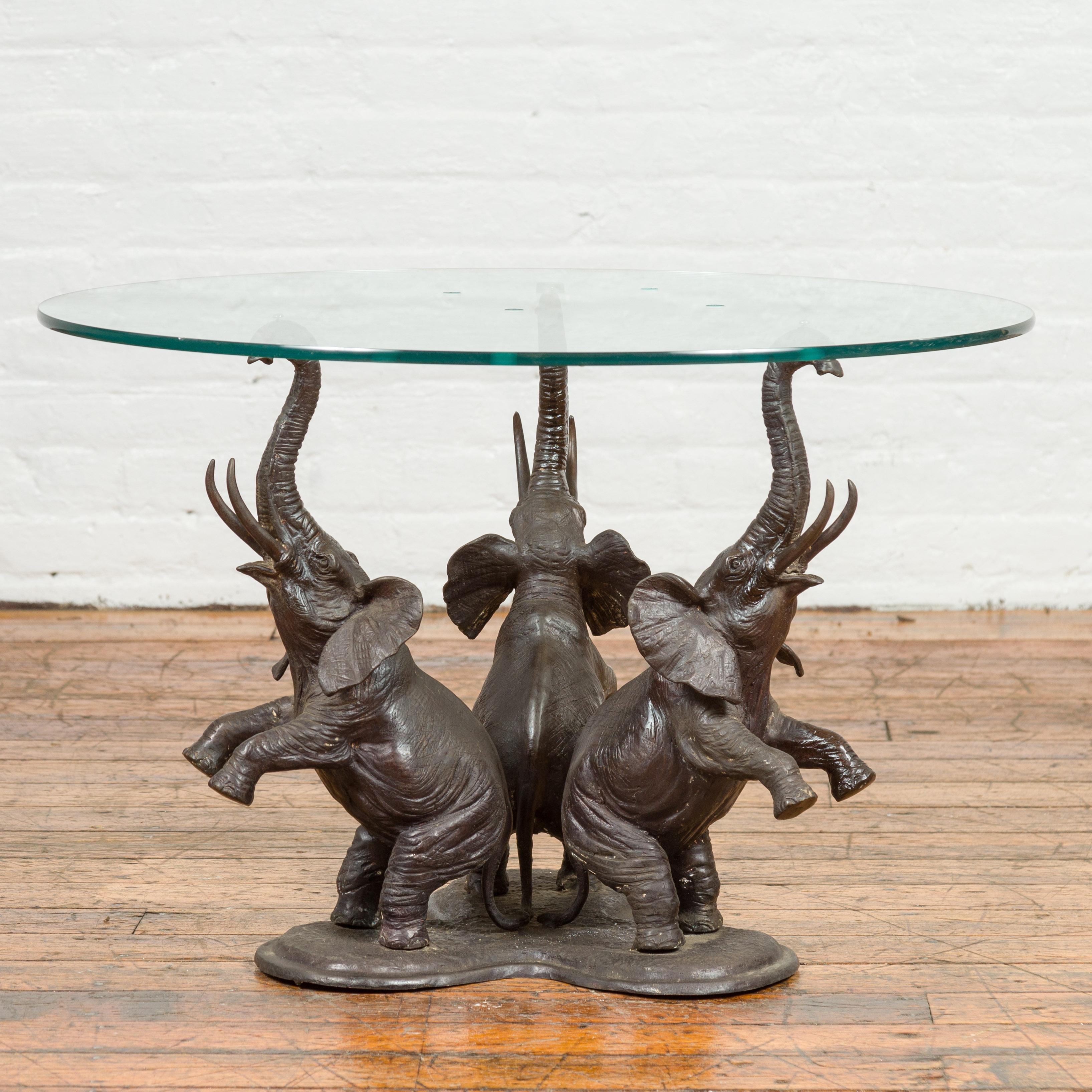 A vintage triple elephant coffee table base from the 20th century with dark patina. The top is not included but shown on the photos to allow a better visualization of the possibilities. Created with the traditional technique of the lost-wax (à la