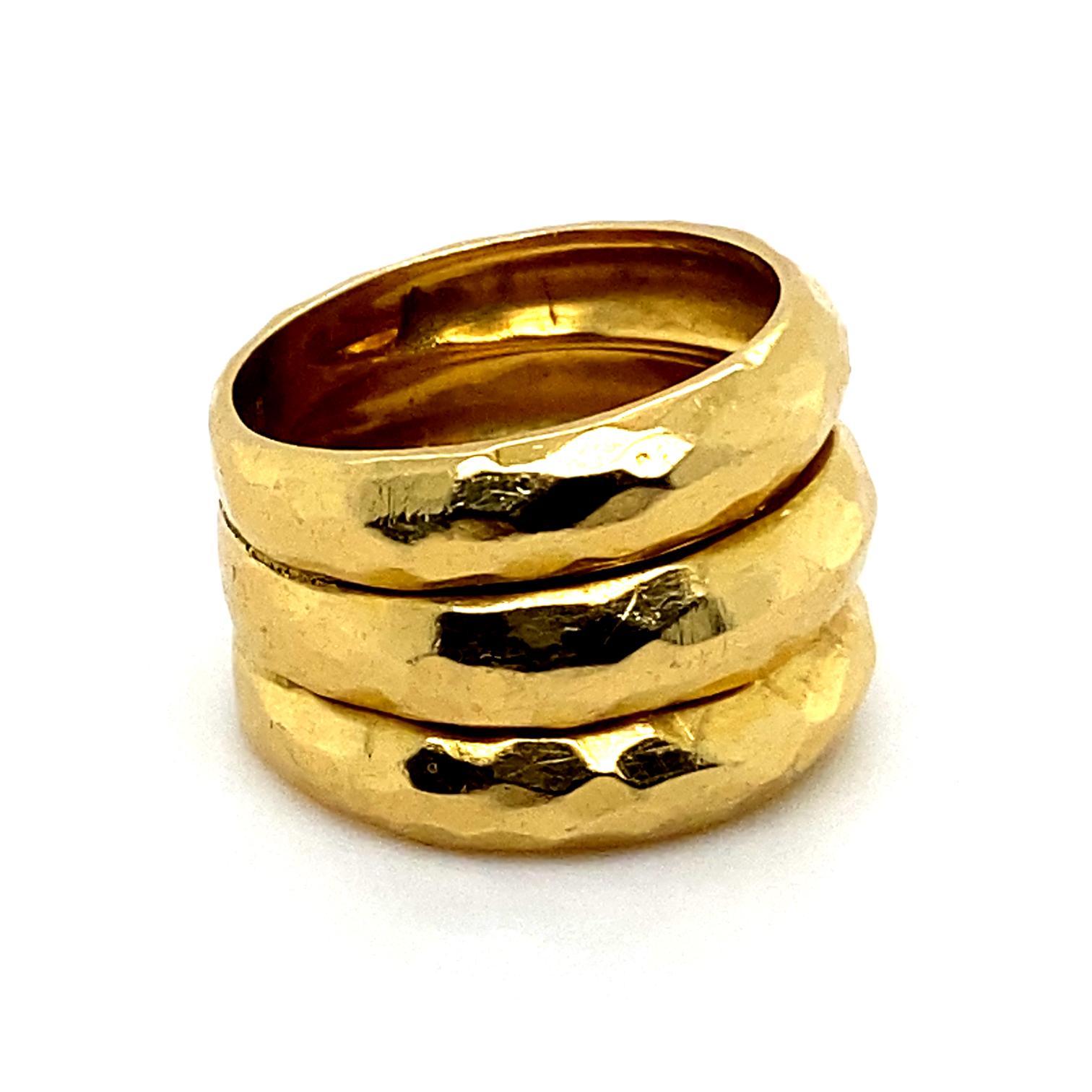 Dreireihiger Vintage-Ring aus 18 Karat Gelbgold

Dieser Ring besteht aus drei übereinander gestapelten Ringen, die in einem kühnen und ungewöhnlichen Design miteinander verschmolzen sind.
Jeder Ring weist gehämmerte und strukturierte Details auf der